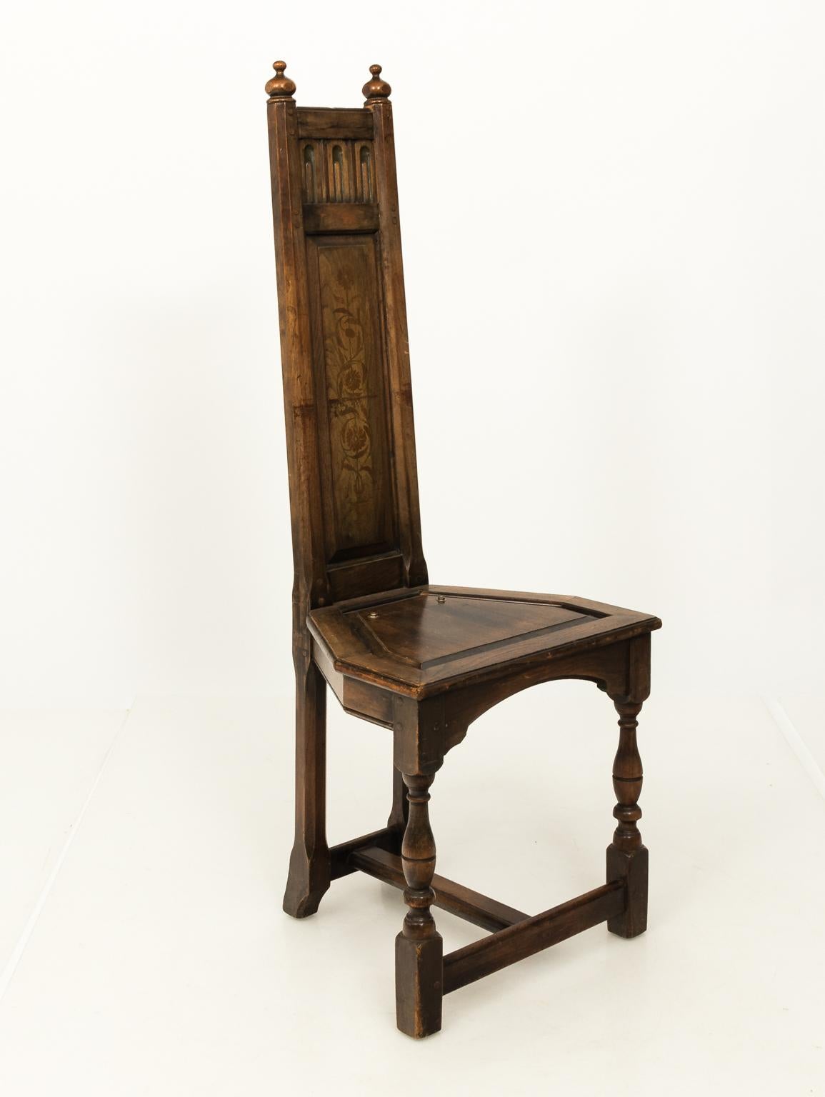 This Arts & Crafts corner chair consists of high wooden splat back embelished with floral inaly and carved frieze.
 