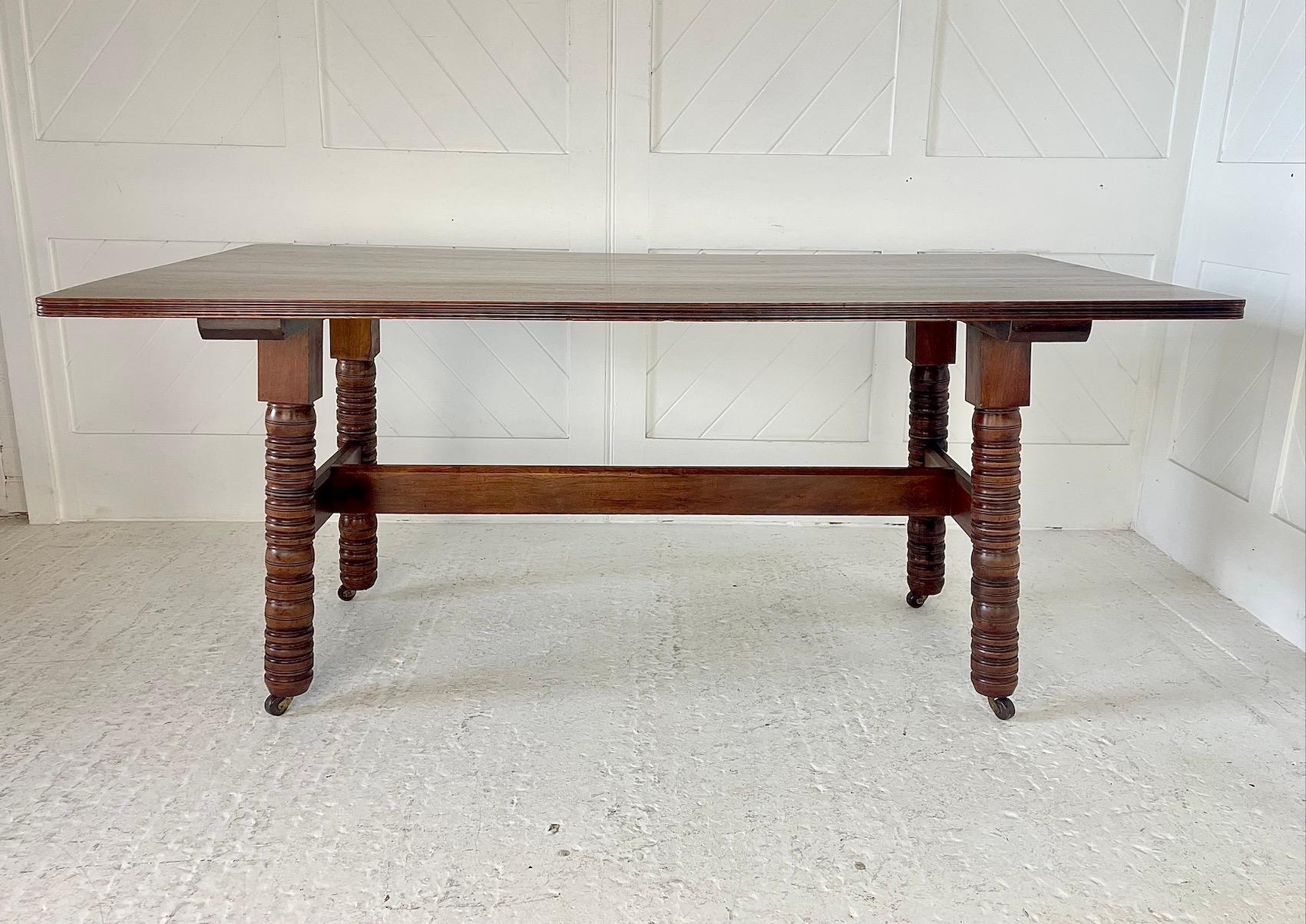 Arts & Crafts rectangular top walnut dining table or work table
Raised on 4 turned supports
Brass and ceramic castors
The legs of this table are splayed and united by a raised ‘H’ stretcher with through tenon detail and chamfered top edge.
Designed
