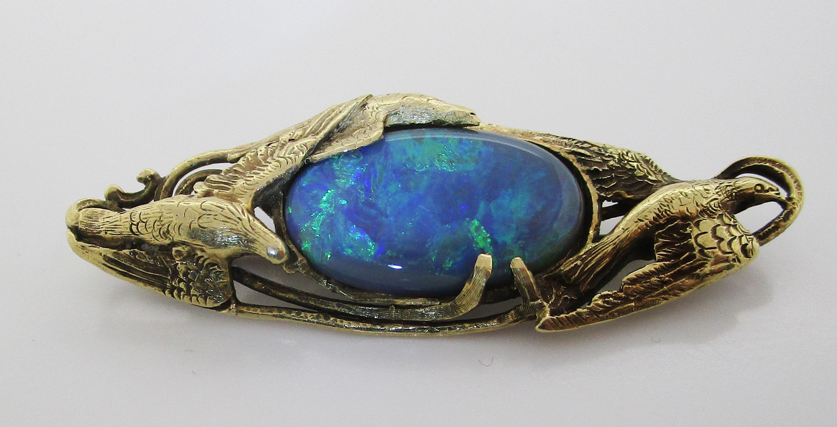 This is a magnificent Arts and Crafts Walton & Co. brooch in 14k green gold featuring an elegant dove design and an enchanting black opal center! The green gold brooch features a design of overlapping doves in flight that is definitive of Arts and