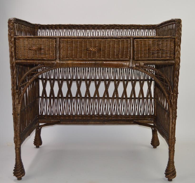 Very stylish woven wicker desk, with oak writing surface top, top shows cosmetic wear to finish, as shown. Great original condition, in original natural unpainted finish, no breaks or repairs, clean ready to use. oak writing surface over three