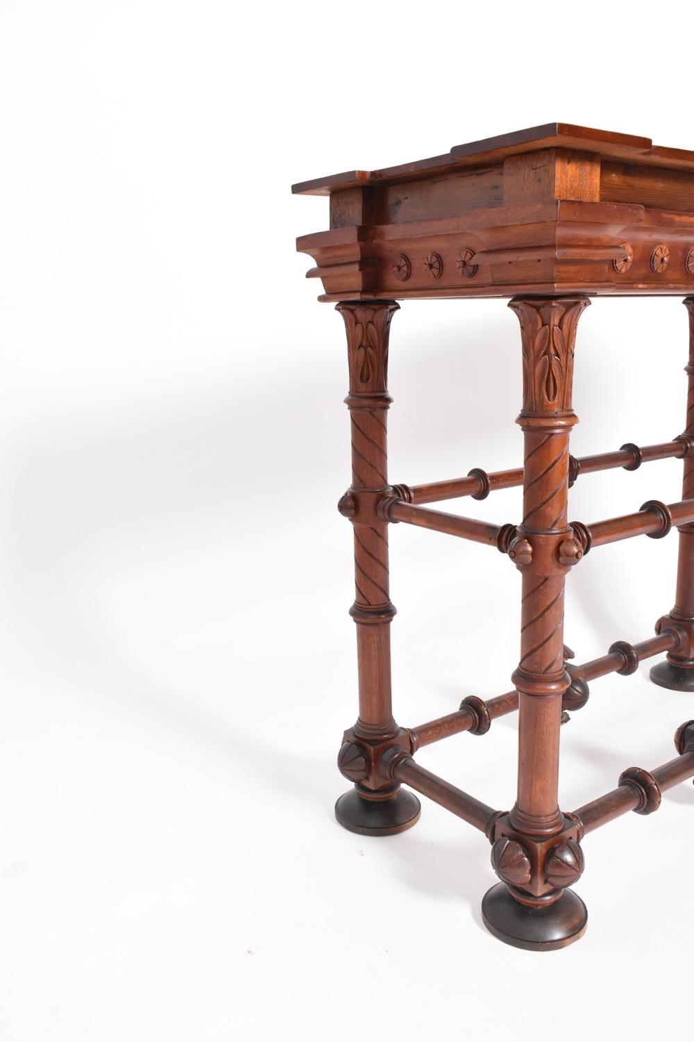 Consola de madera artesanal sobre cuatro patas de madera torneada con motivos florales y unidas por un separador. Inglaterra, década de 1910.
