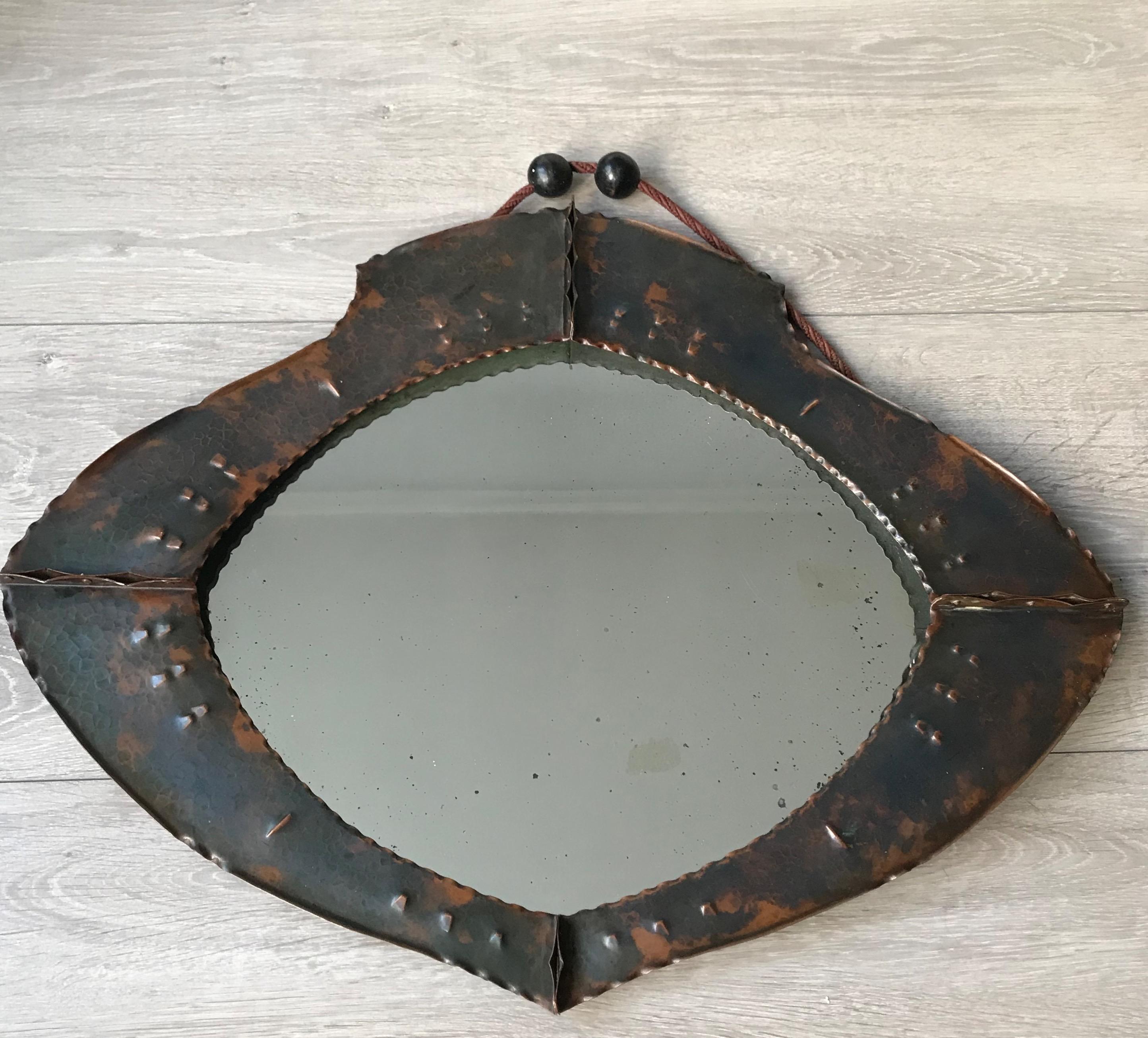 Early 1900s artistic design Arts & Crafts mirror with a crustacean look and feel.

This all-handcrafted, wide shape Arts & Crafts antique with its original, thick glass mirror is an absolute joy to own and look at. The perfectly symmetrical design