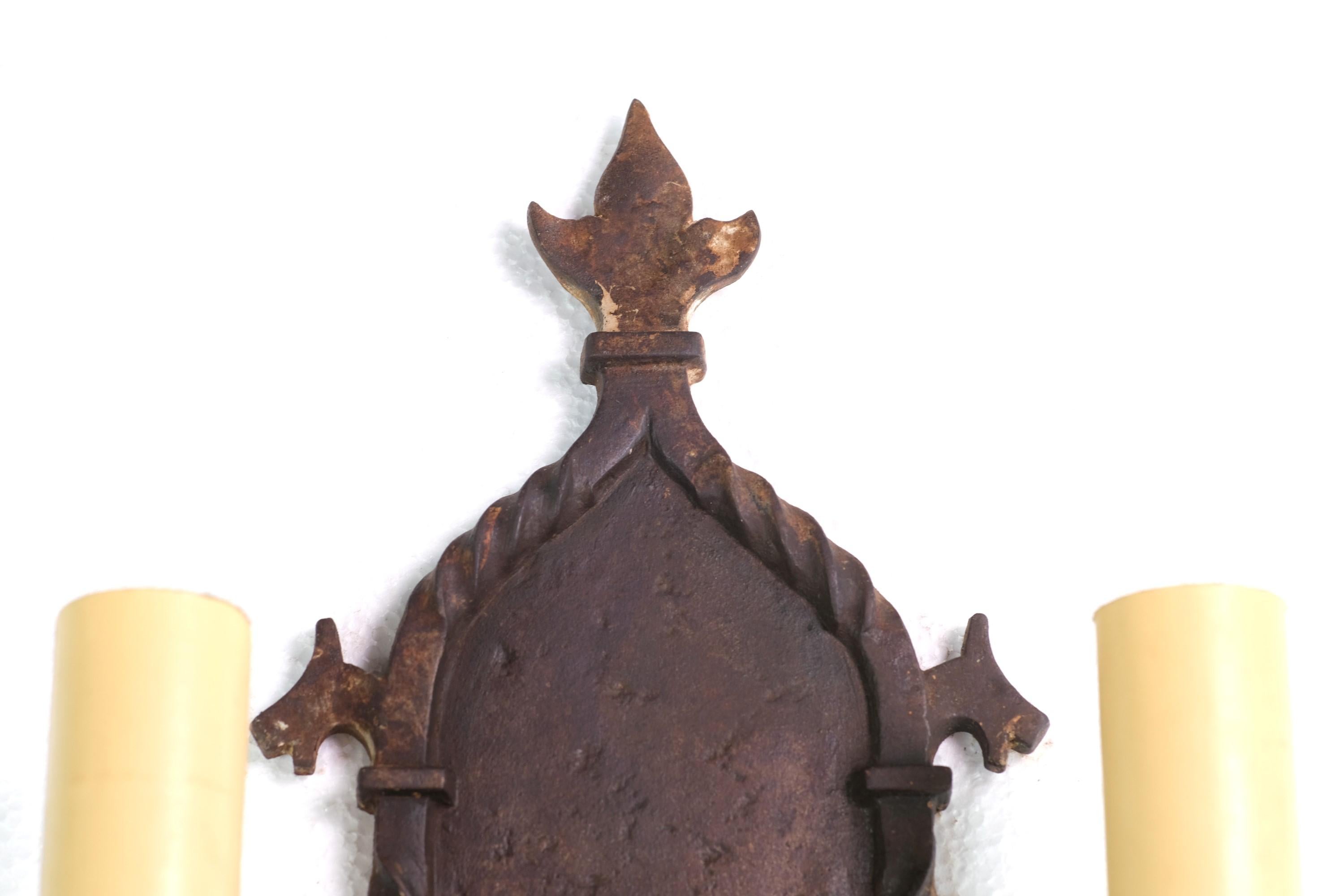 Early 20th century hand hammered Arts & Crafts sconce. Made from wrought and cast iron, this sconce features two arms and Griffin details. Price includes restoration. Small quantity available at time of posting. Priced each. Please inquire. Please