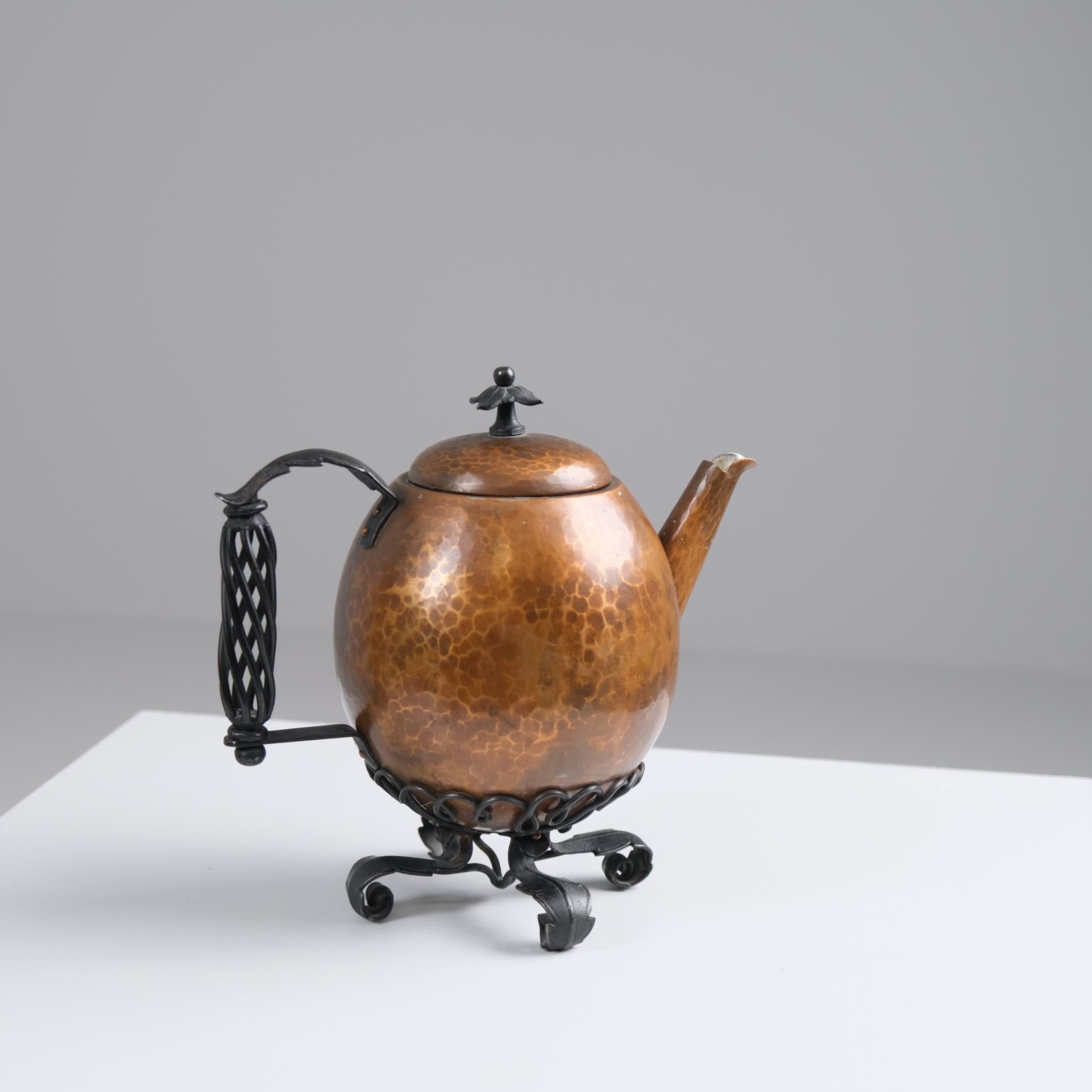 Une magnifique théière martelée à la main en cuivre et fer forgé par Antti Hakkarainen. La paix comprend une théière en cuivre avec des poignées décoratives en fer forgé et un support. Magnifiquement exécuté et en très bon état vintage. Cette pièce