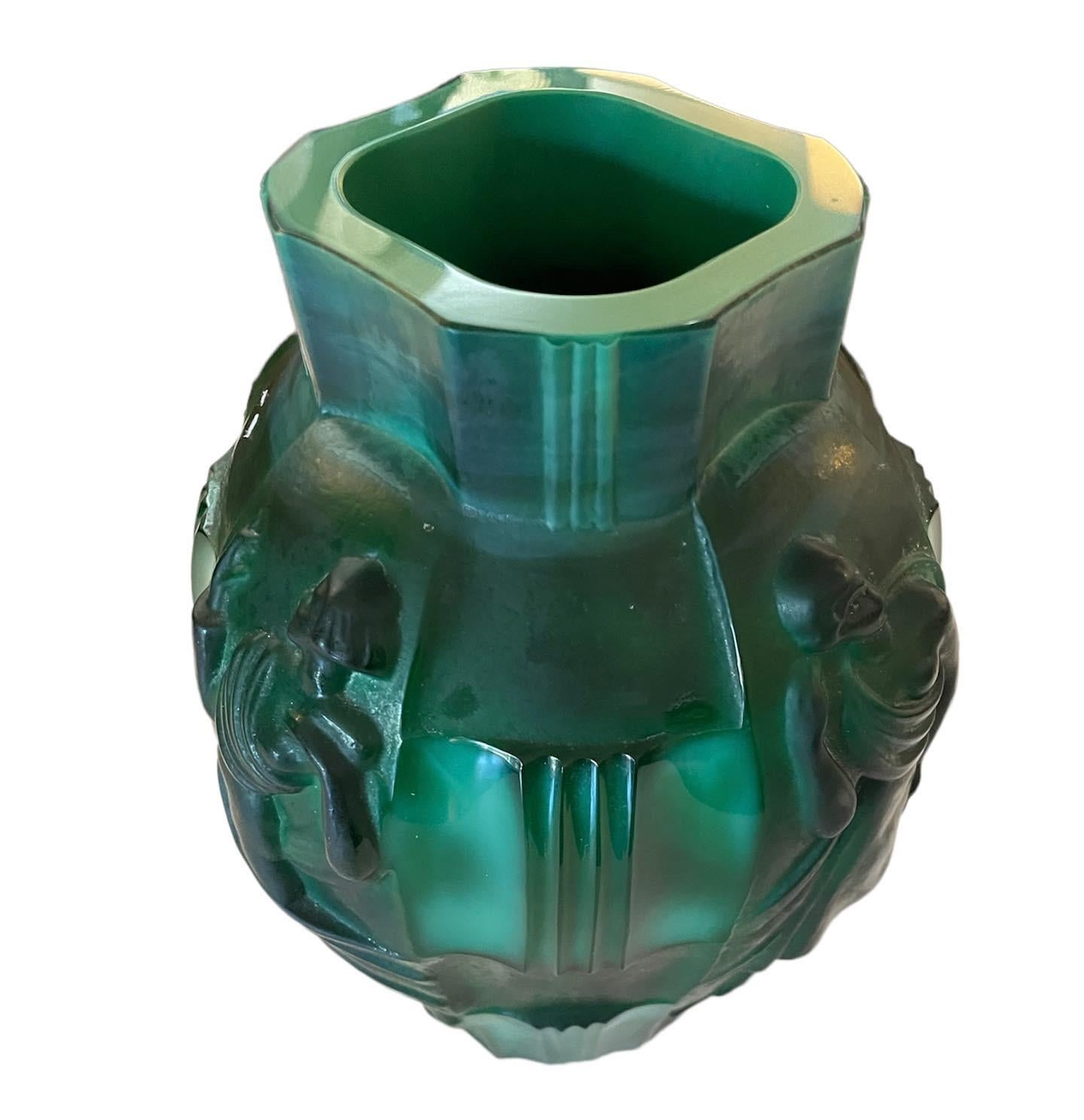 A absoluly stunning Art Deco Czechoslovakian malachite green glass vase moulded with figures designed by Artur Pleva for Curt Schlevogt. The vase combines polished and matted elements with four semi-clad female dancing figures set between carved