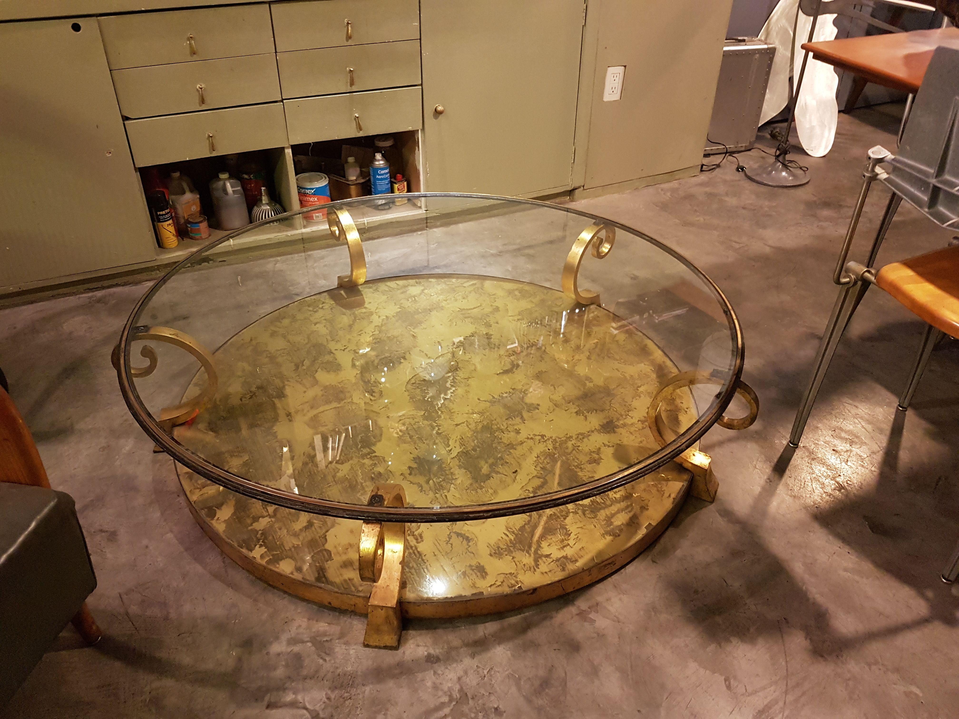 Elegant Mexican Mid-Century Modern 2-level bronze coffee table. Round glass top cover over rolled supports and eglomisé glass bottom cover. 

Arturo Pani was a Mexican furniture designer. He studied in the École des Beaux Arts in Paris along his