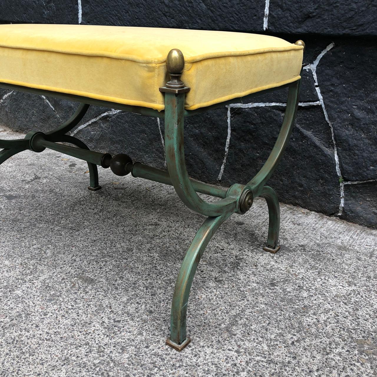 Mexican Mid-Century Modern patinated steel stool with brass details by Mexican designer Arturo Pani. The ottoman has been reupholstered with a fine yellow velvet fabric. The ottoman has a missing knob on the side.