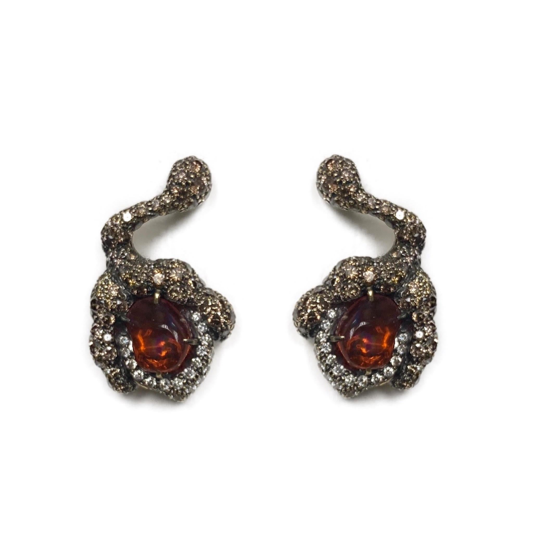These unique fire opal flower bud earrings feature mesmerizing fire opals and diamonds set in 18 karat blackened gold. Two cabochon cut fire opals weighing 1.65 carats are surrounded by 3.53 carats of diamonds, resulting in the intricate and