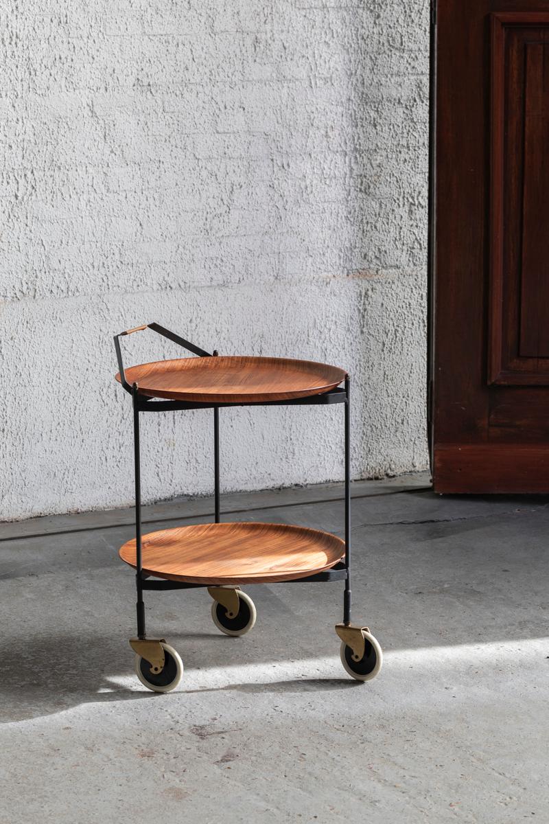 Serving trolley ‘Impala’ by Ary Fanérprodukter Nybro produced in Sweden around 1950. Round two tier trolley with two teak veneer trays that can be taken off. It rests on a foldable, metal frame on wheels. The wheels roll very easy. The frame has a