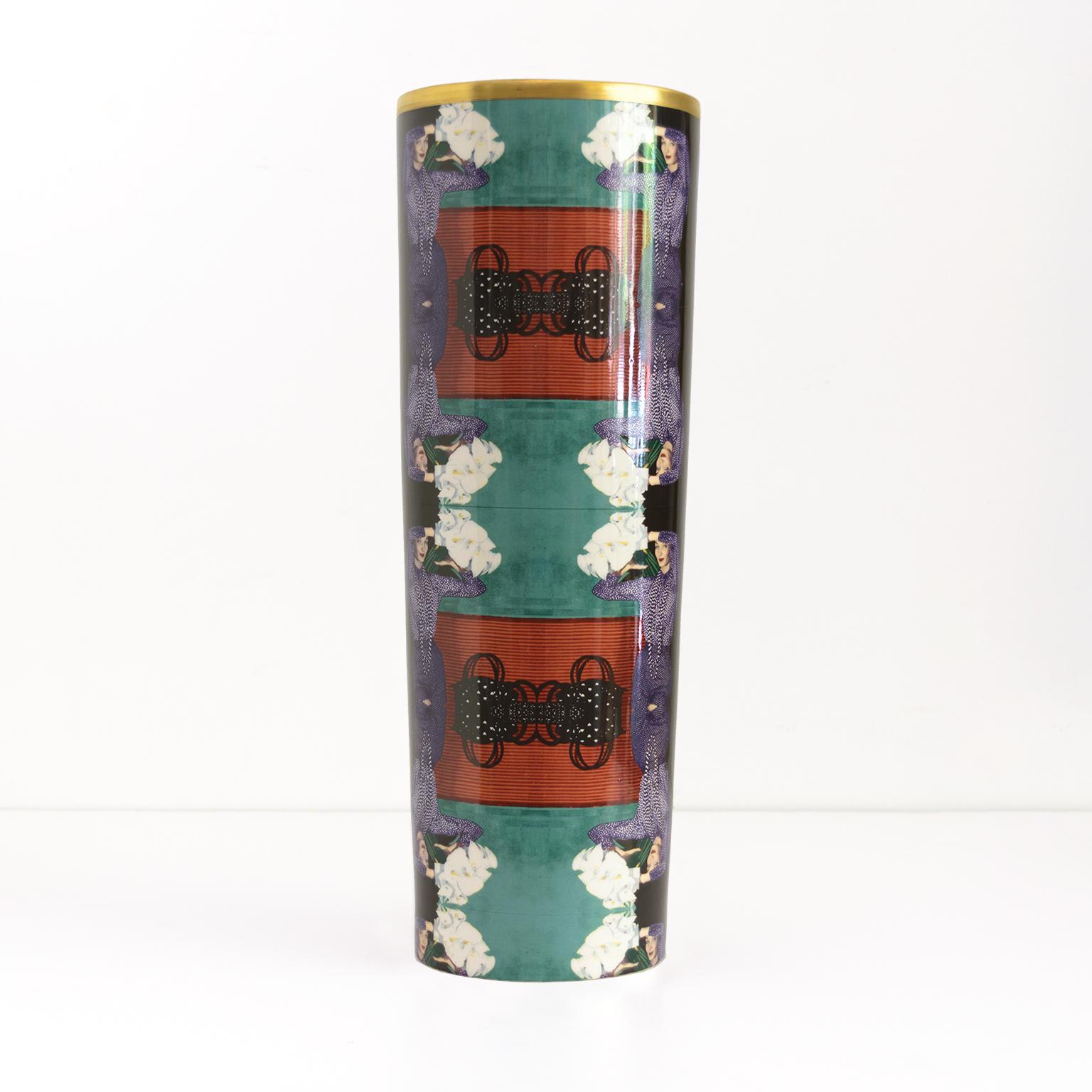 A Scandinavian Modern, cylindrical porcelain vase designed by Åsa Lindström for Rörstrand. Decorated with a repeating pattern of a young women wearing a purple dress holding lilies. Signed Rörstrand, Åsa Lindström, dated 2000.