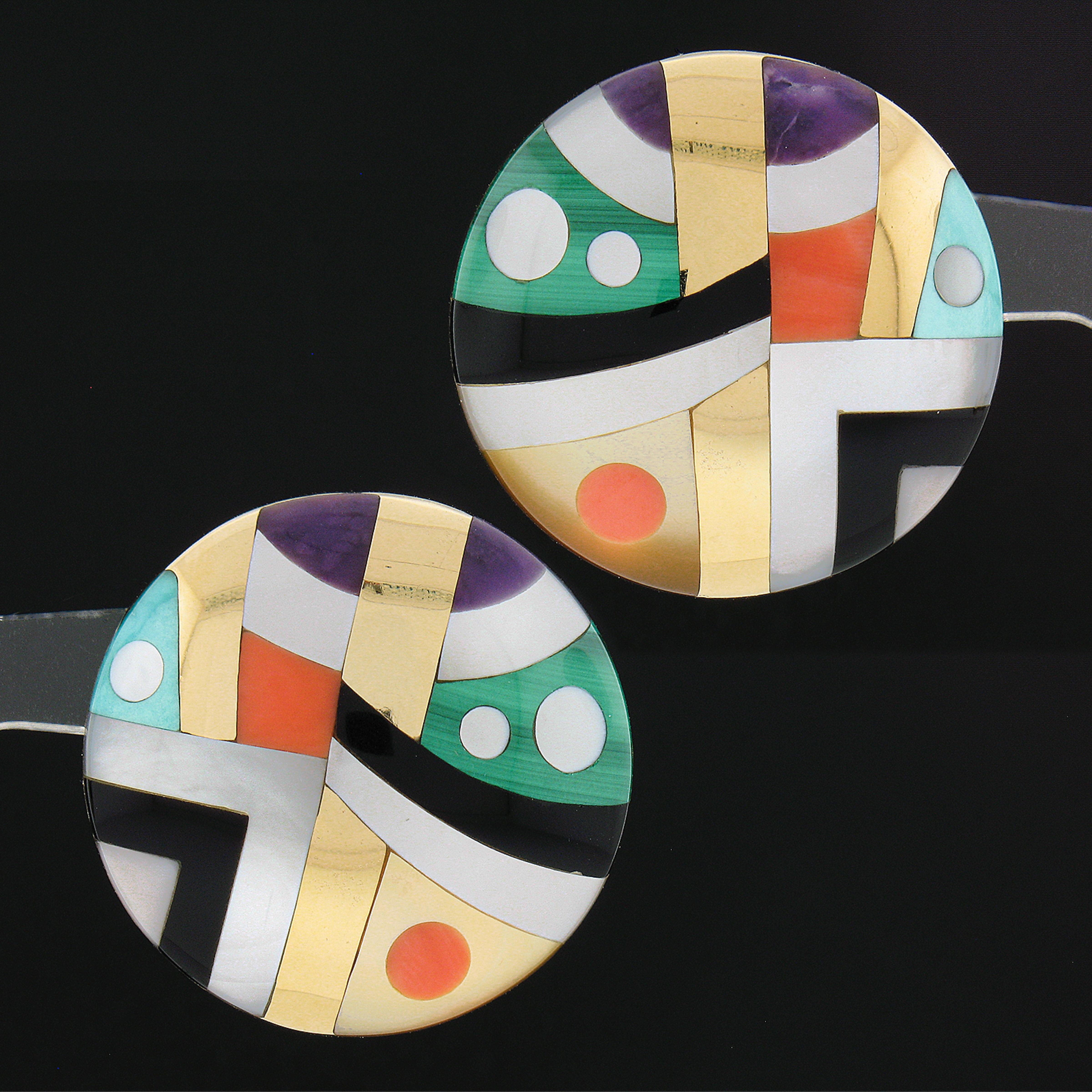 Here we have a magnificent pair of large button earrings designed by Asch Grossbardt that are crafted from solid 14k yellow gold, featuring pieces of natural black onyx, coral, mother of pearl, malachite, and amethyst stones neatly inlaid set in a