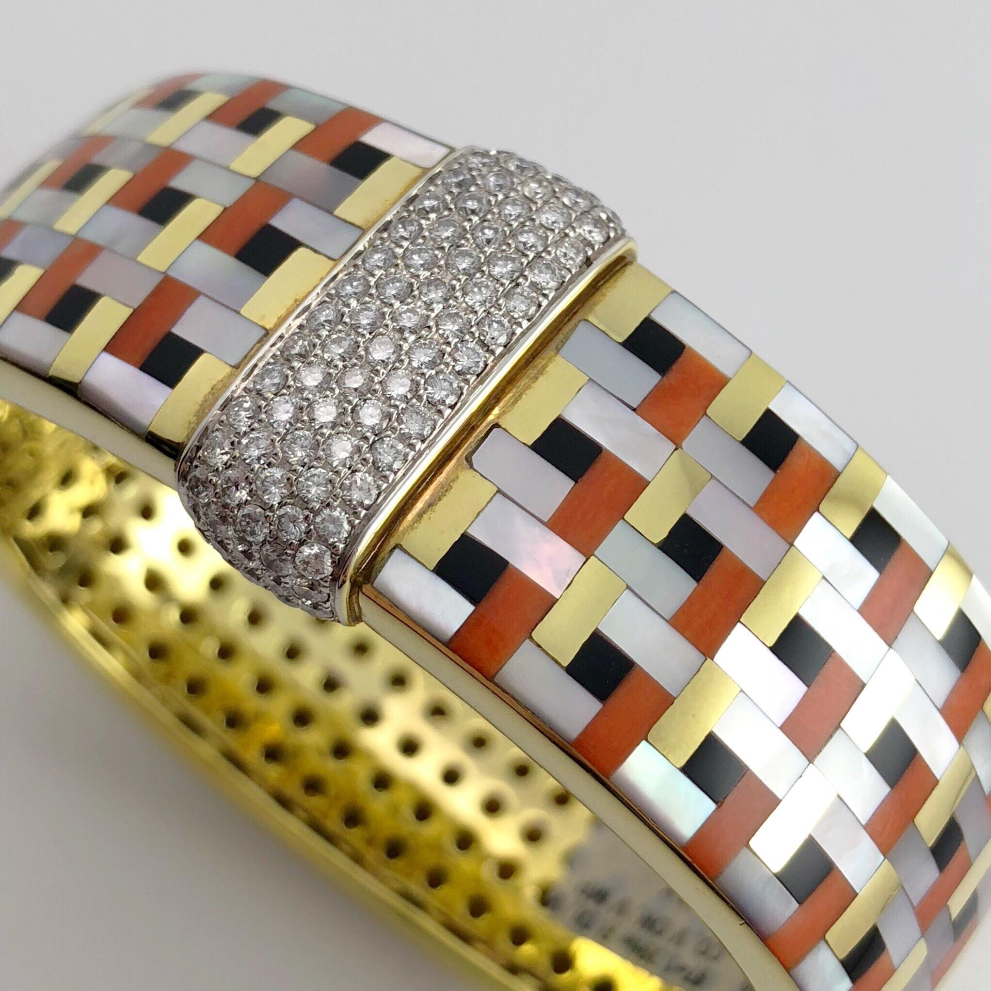 This stunning Asch Grossbardt 18 Karat yellow gold bracelet is inlaid with Coral, Black Onyx, and Mother of Pearl. Intricately cut geometric shaped stones form a basket weave art deco inspired pattern. The center of the bracelet is set with with 87