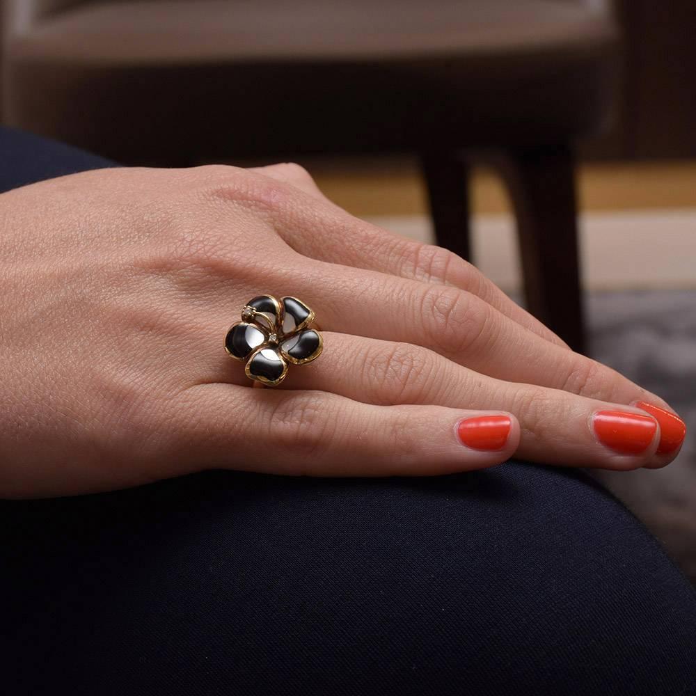 This lovely flower ring is composed of 5 petals. Each petal is inlaid with black onyx and mother of pearl. Two round white brilliant diamonds .03 carats create the stamen.
Handcrafted by Asch Grossbardt ,based on ancient jewelry making traditions of