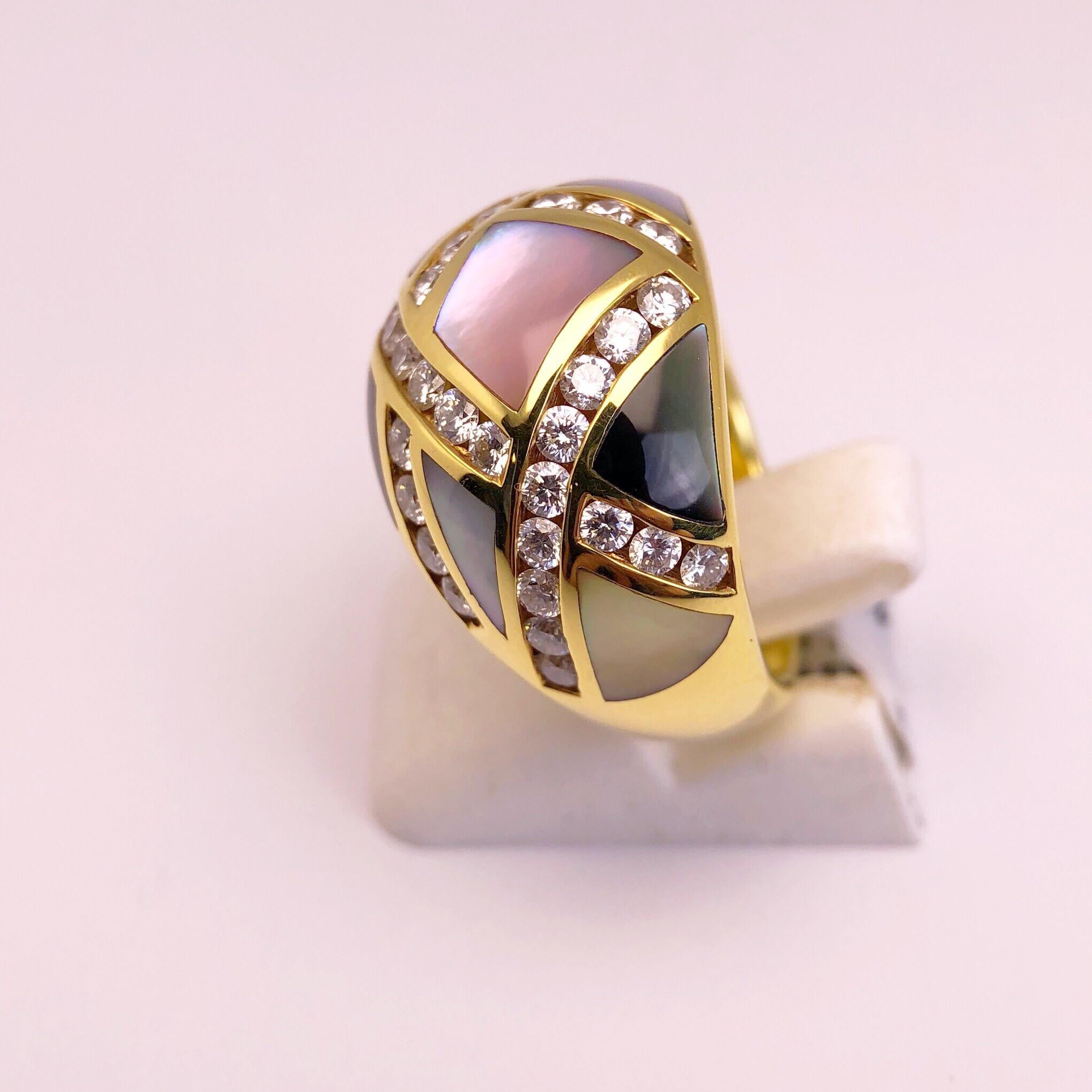 This lovely Asch Grossbardt ring in 18 karat yellow gold. The stunning dome shaped ring is set with geometric shapes of mother of pearl. The mother of pearl are soft shades of yellow, pink, white and grey. Each section is outlined with round