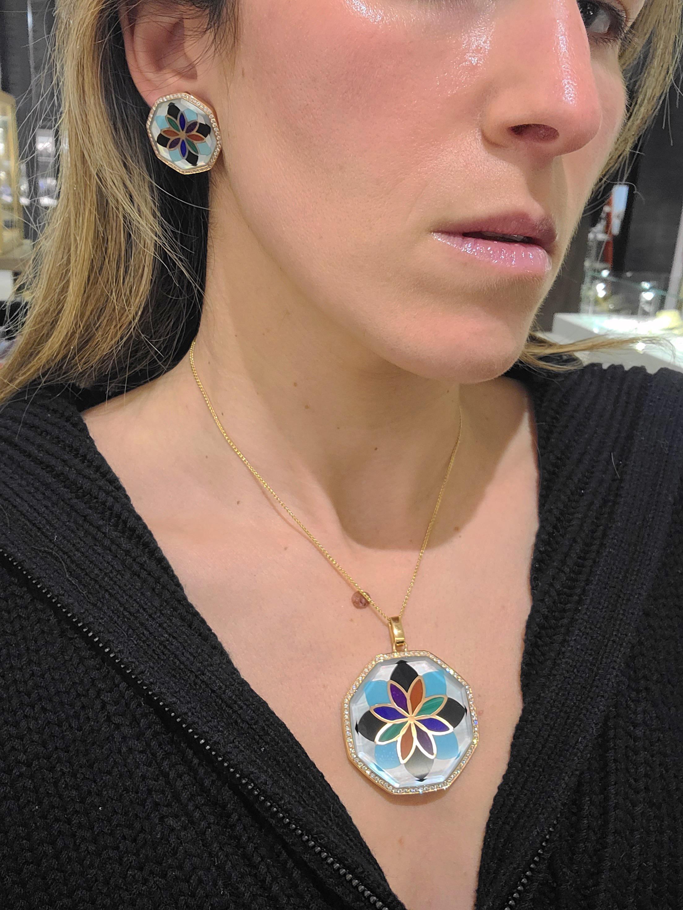 Designed by Asch Grossbardt this impressive medallion earrings feature inlaid turquoise, onyx, coral, malachite, lapis lazuli and white mother of pearl in a mosaic flower pattern. A beveled rock crystal lays on top of the fine inlaid work creating a