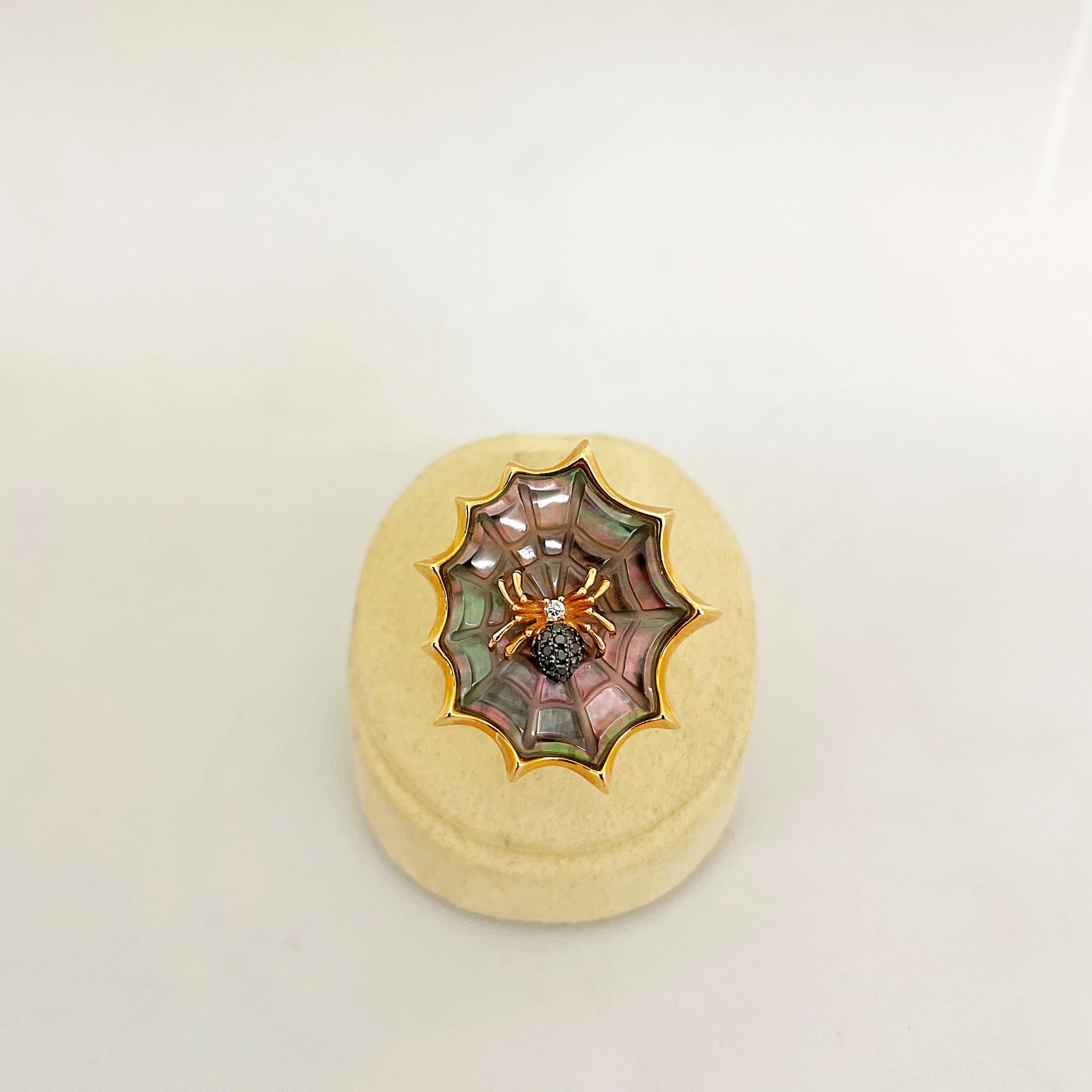 Cette bague unique en or rose 18 carats est conçue comme une araignée assise sur sa toile. L'araignée en or rose est sertie de 0,05 carats de diamants noirs et de 0,02 carats de diamants blancs. La toile magnifiquement détaillée est sculptée à la
