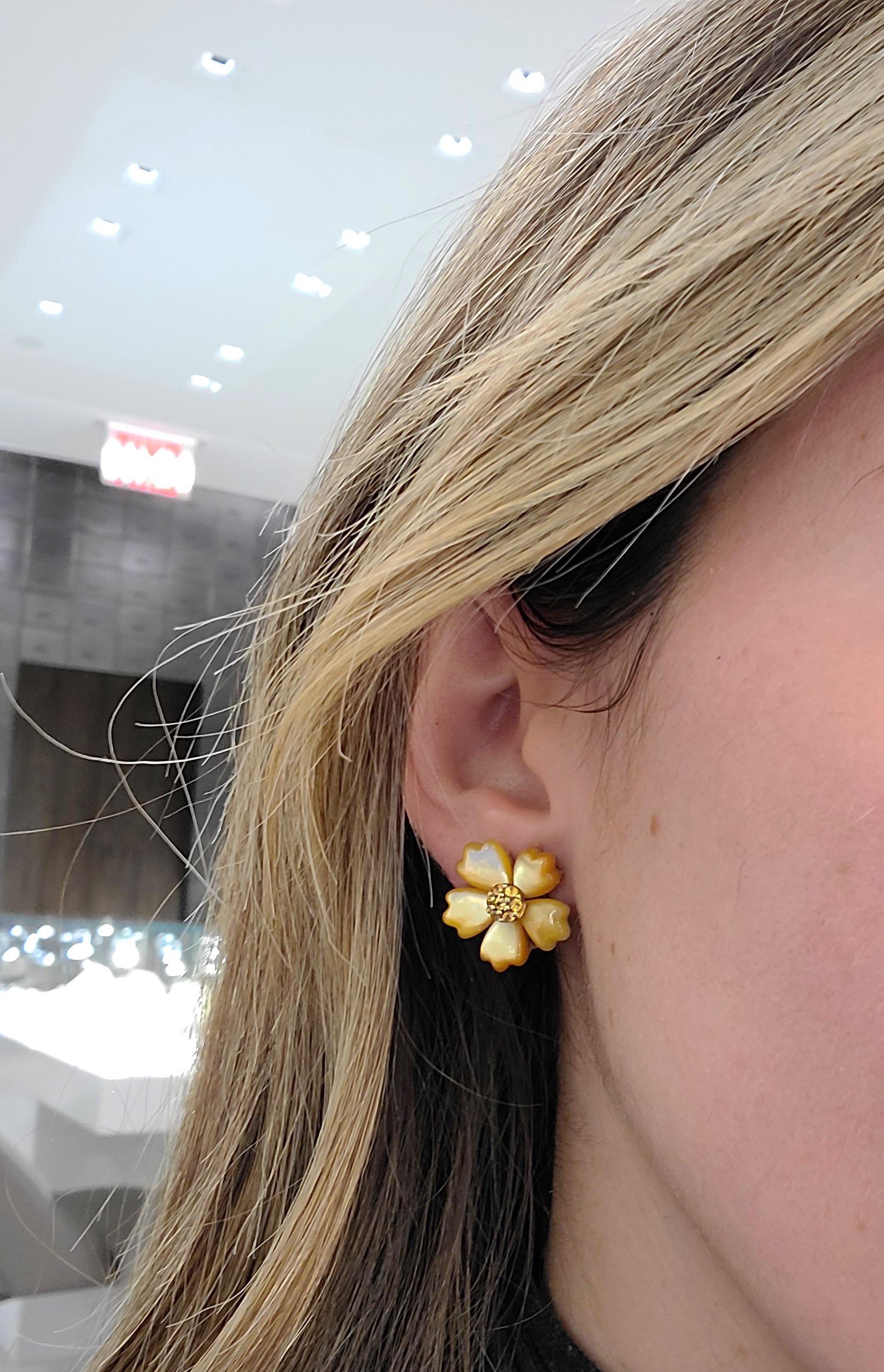 These timeless and wearable Asch Grossbardt Earrings are composed of 5 hand carved golden mother of pearl petals which surround a .42Ct. Yellow Sapphire center. The beautiful golden mother of pearl petals glisten beautifully in the light. 
Earrings