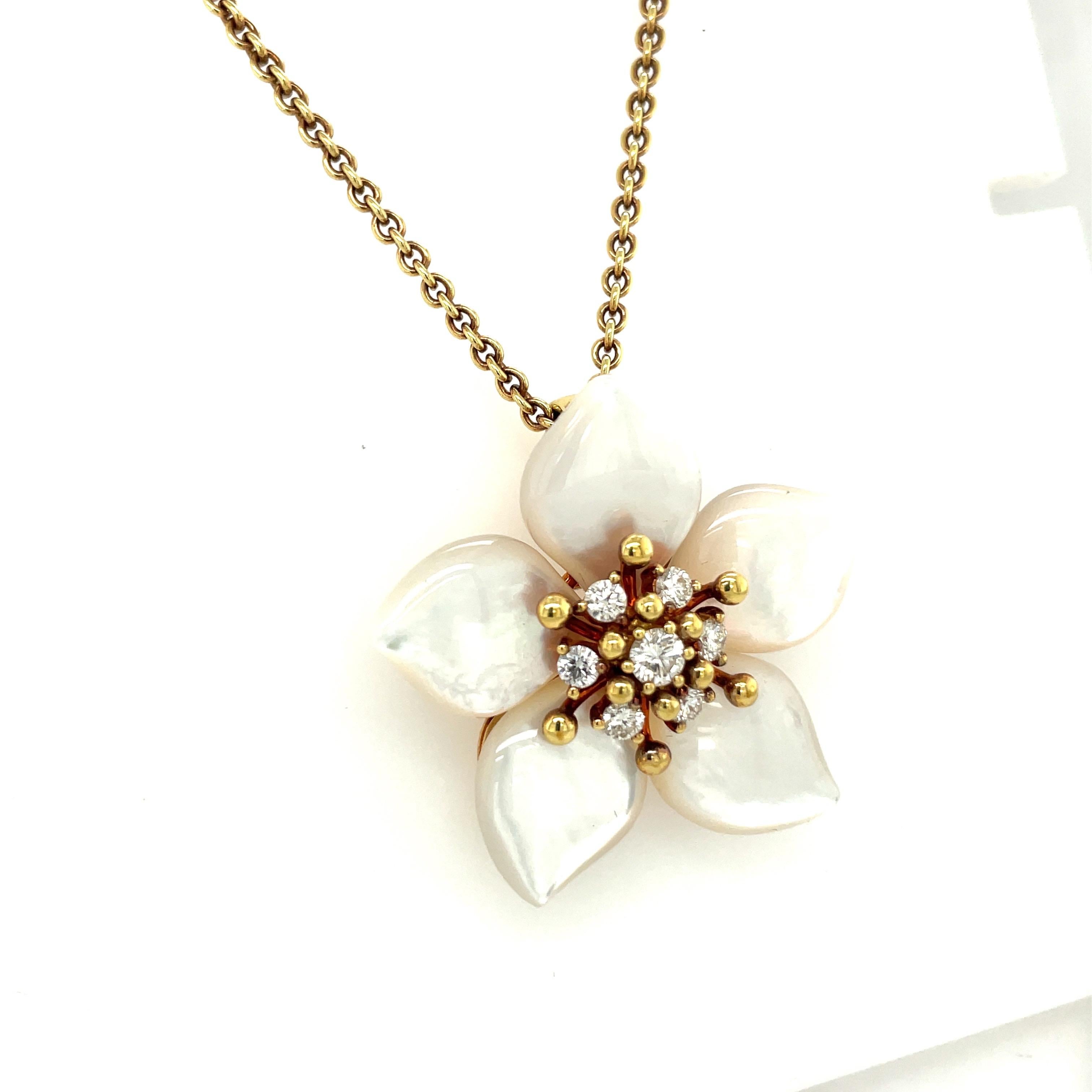 Designed by Asch Grossbardt, this 18 karat yellow gold flower pendant is a unique piece. The petals are set with beautifully shaped mother of pearl. The center of the flower is set with 7 round brilliant diamonds totaling 0.85 carats. The flower