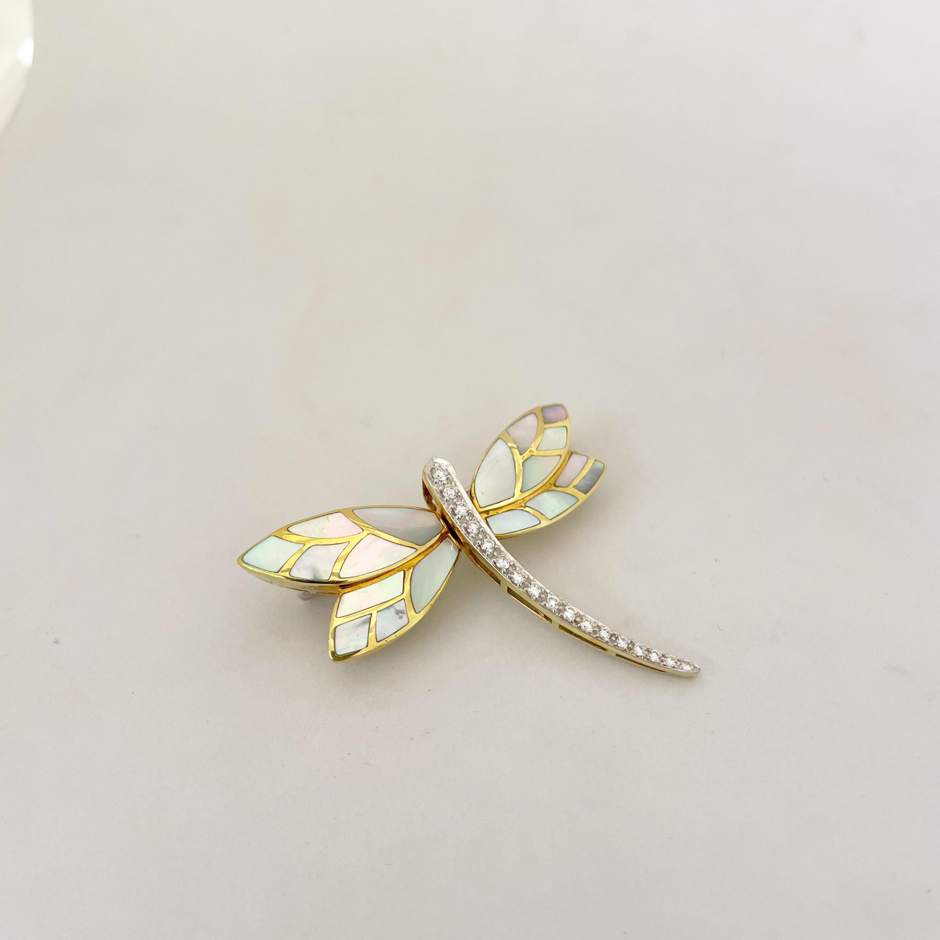 Designed by Asch Grossbardt , this 18 karat yellow gold brooch is intricately set with mother of pearl and round brilliant diamonds. The brooch measures 2
