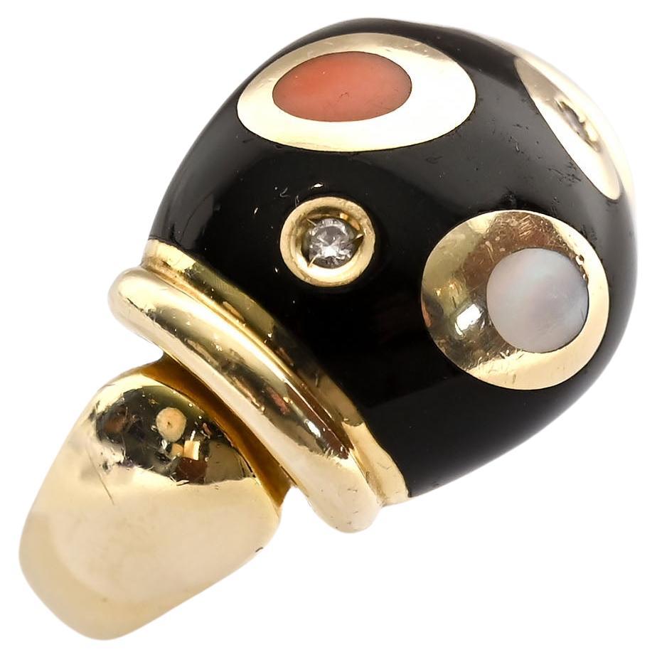 Wonderful Modernist design ring by Asch Grossbardt. Inset in the black onyx ground are coral; mother of pearl and diamonds, encircled in gold. The stones are both round and oval. The ring is size 6 1/2 and can be made larger or smaller. The front of