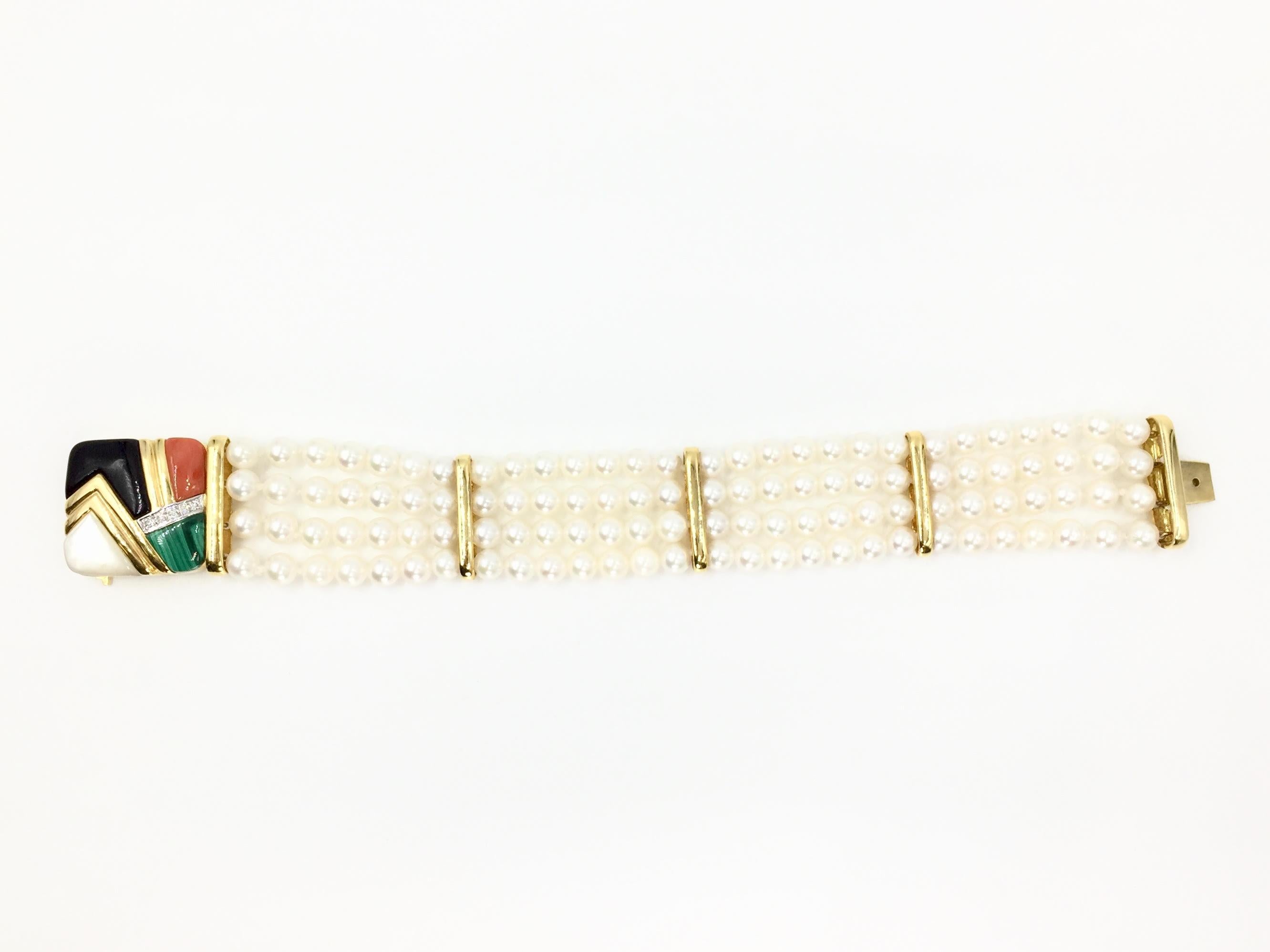 Asch Grossbardt 14 karat yellow gold four strand white cultured pearl bracelet featuring a gorgeous clasp with diamonds and expertly laid malachite, coral, onyx and mother of pearl. Stones on clasp are in excellent condition, free of cracks, chips