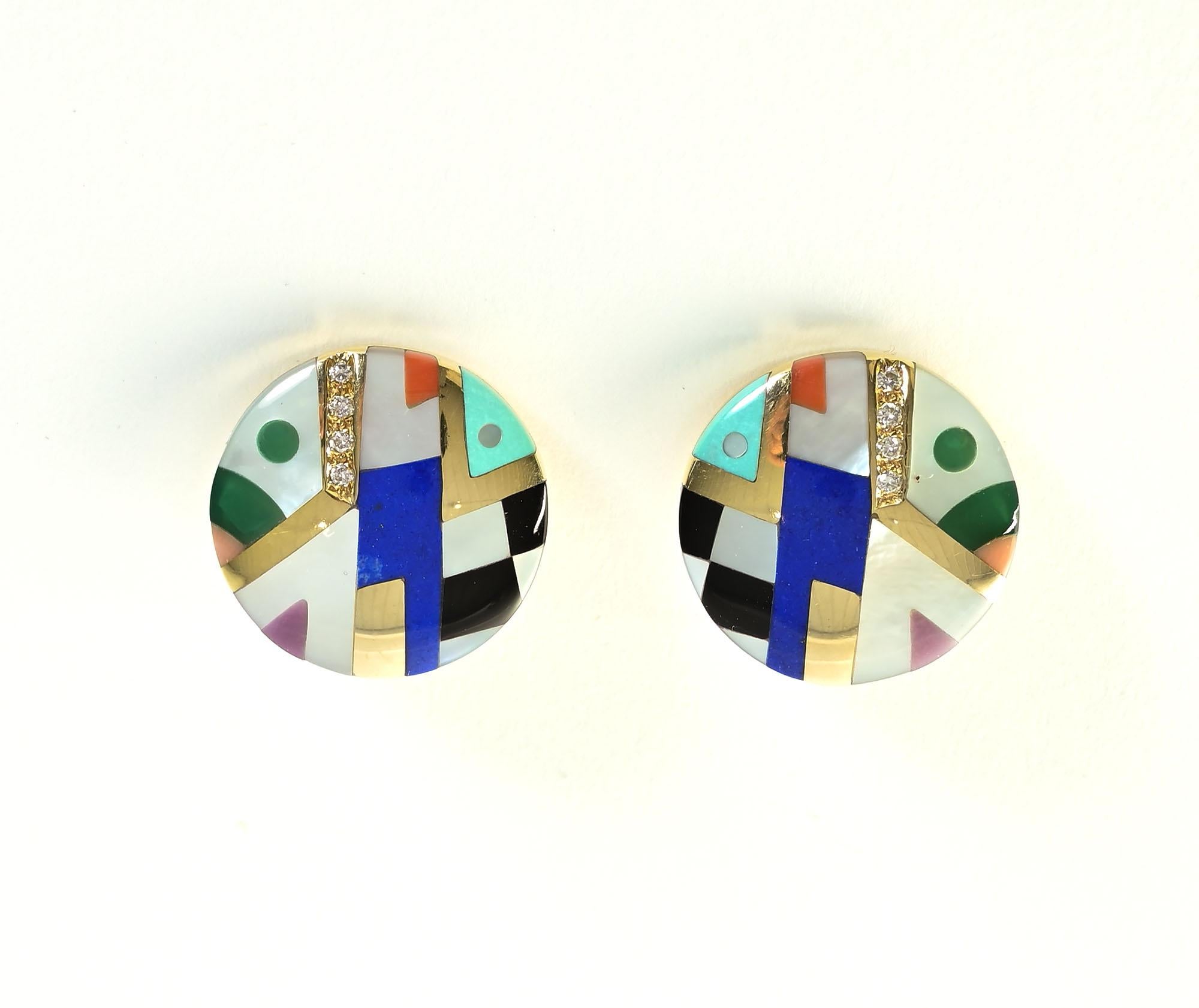 These earrings with a variety of inlaid stones are typical of the designs of American designers, Asch Grossbardt. Among the stones with which the 14 karat round earrings are inset are: black onyx; lapis lazuli;  sugilite and diamonds. Round and hard