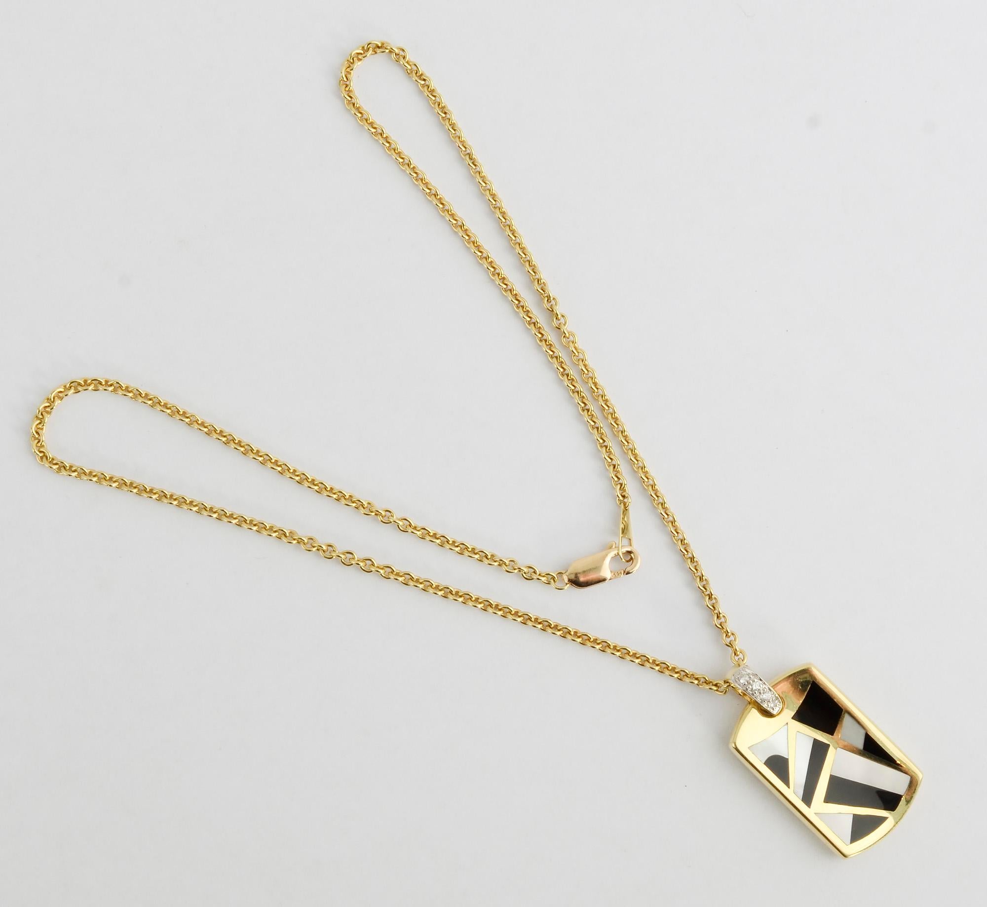 Geometric design pendant necklace by Asch Grossbardt with the use of varied inlaid stones for which they are known. The pendant has mother of pearl and black onyx. The bail is set with diamonds. The pendant is a slightly concave shape. It can also