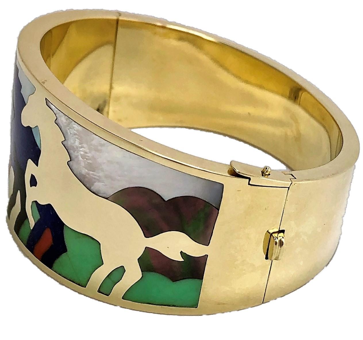 Fabulous gold and multiple stone inlay stampeding horses themed bangle by 
Asch Grossbardt. The 14k yellow gold bangle is hinged on one side, and measures
1 1/4 inches across the front at the widest point and tapers down to 5/8 inch at
the back.