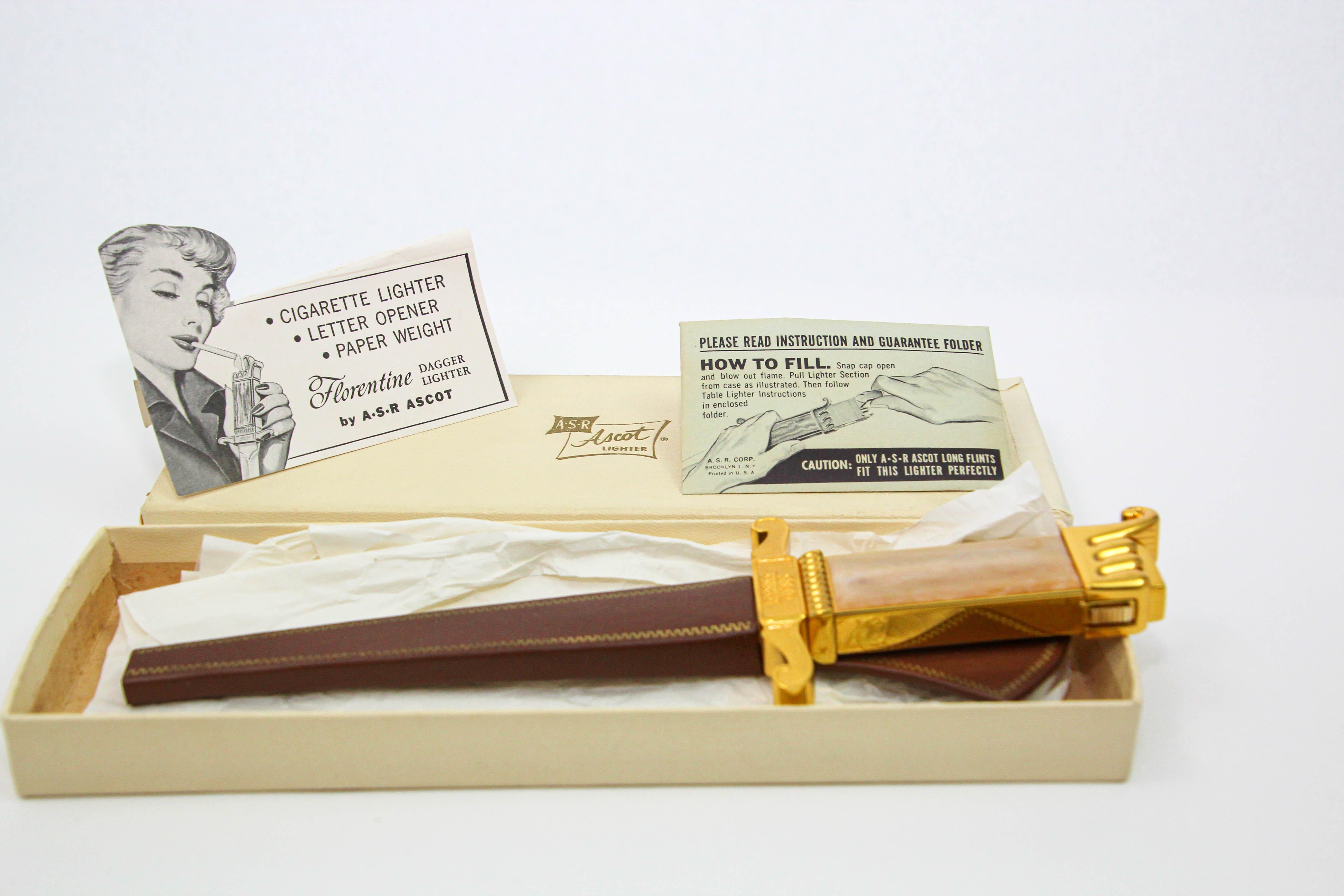 Ascot Florentine Dagger Feuerzeug Brieföffner Briefbeschwerer.
Dies ist ein sehr einzigartiges Feuerzeug Brieföffner kommt in Original-Box und Scheide.
Amerika, 1952, hergestellt von der American Safety Razor Co.
Vintage Dagger-Form Brieföffner mit
