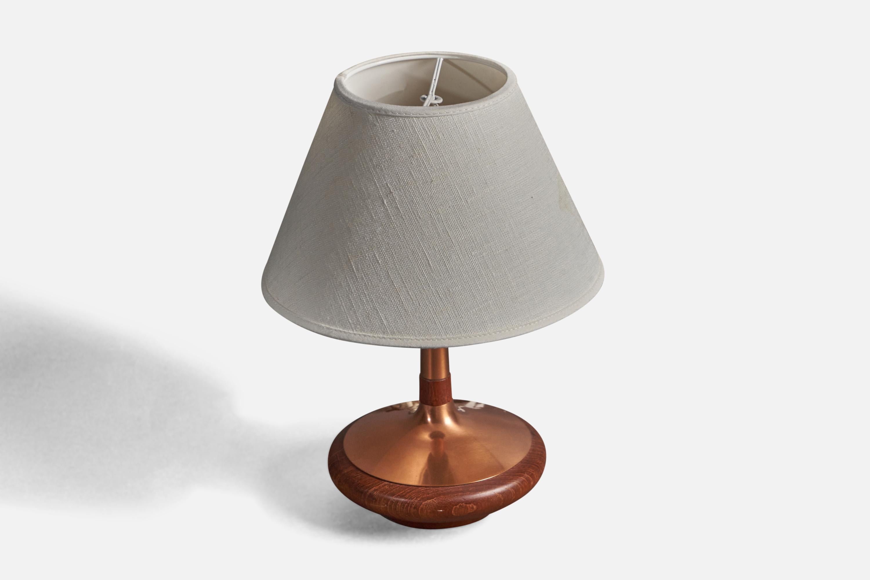 A small table lamp or desk light. Designed and produced by ASEA, Sweden, 1960s. Turned teak and copper details. Stamped with makers mark and Swedish production label.

Lampshade attached on lightbulb-clip is not included in purchase. Dimensions