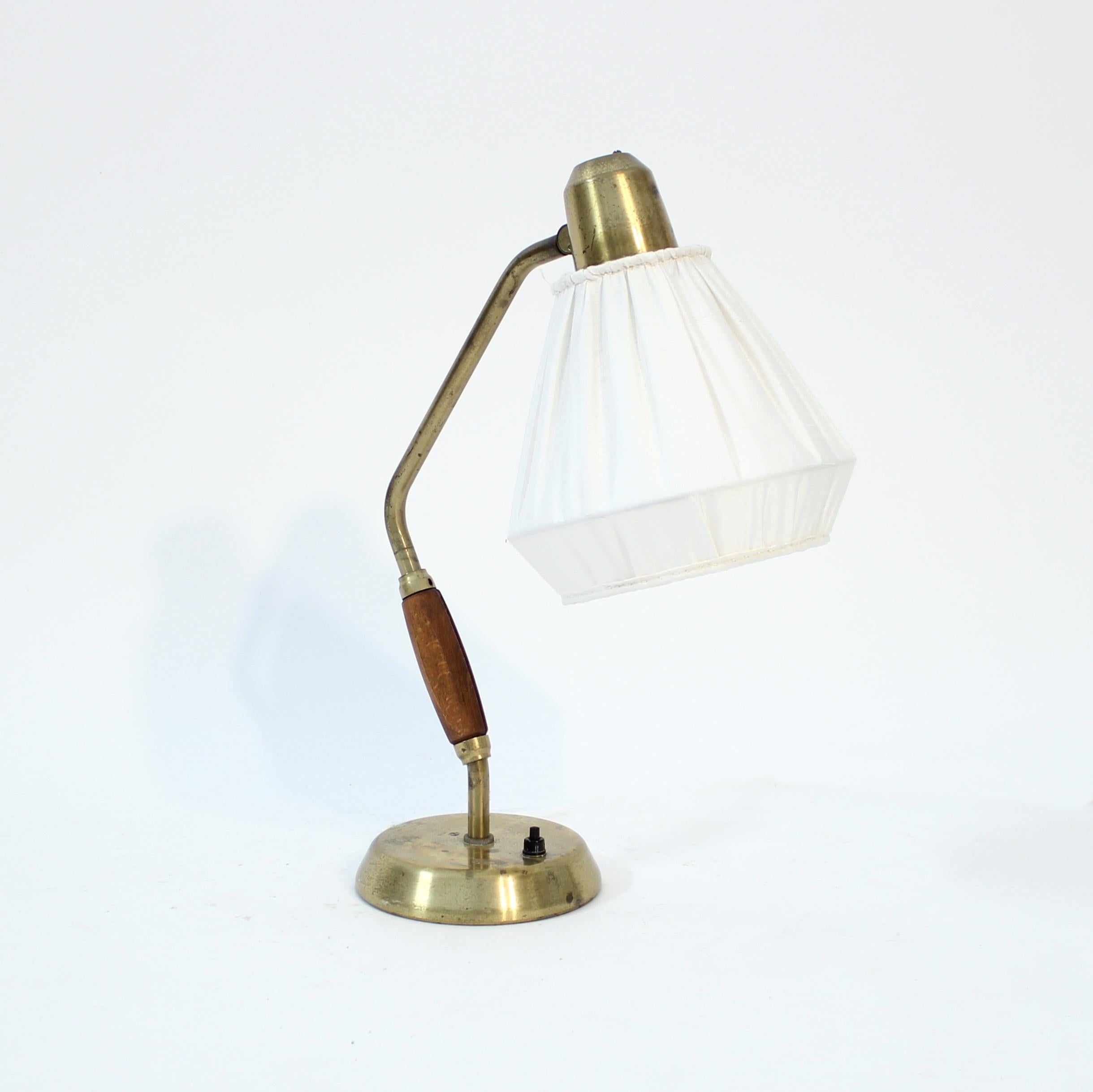 ASEA table or desk lamp in brass with teak handle and white shade. The light switch is on the base. Good untouched vintage condition with light ware and patina consistent with age and use.