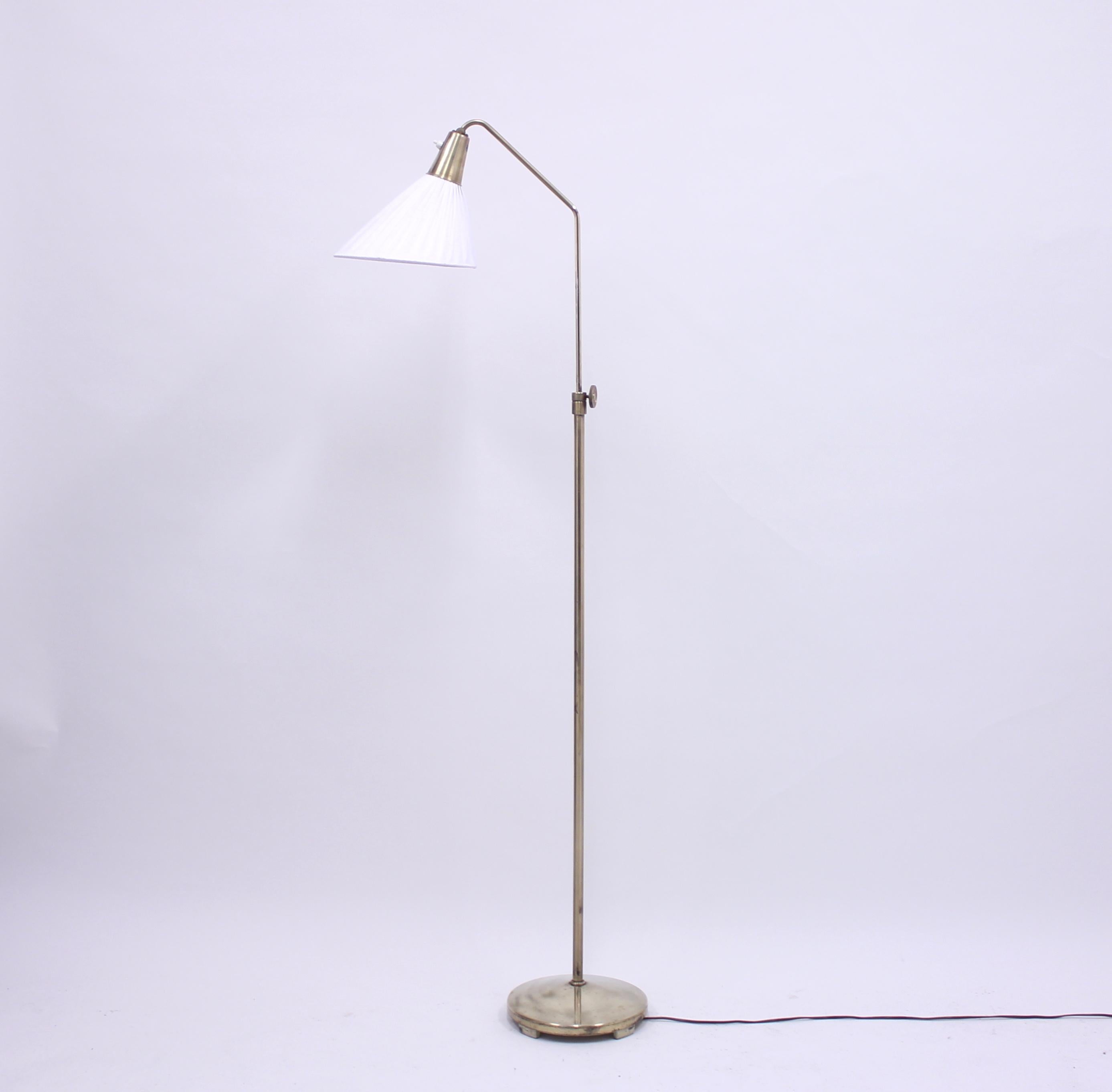 Brass floor lamp manufactured by ASEA in the 1950s, attributed to Hans Bergström who designed many lamps for the brand. Height adjustable between 135-160 cm. Original shade with new fabric. Very good vintage condition.