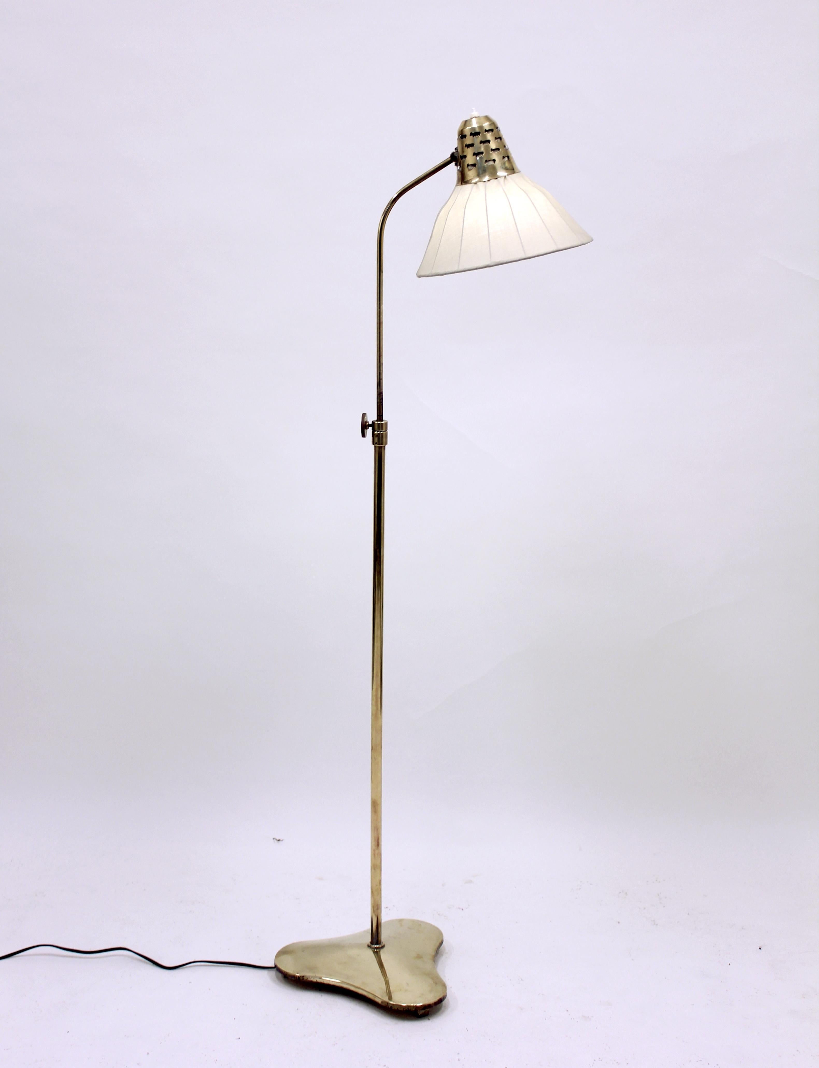 Brass floor lamp with clover shaped base and external brass bulb holder with relief holes depicting sheeps. Height adjustable between 122-147 cm. Newly polished brass with original shade and fabric. New wiring and electric components. Very good