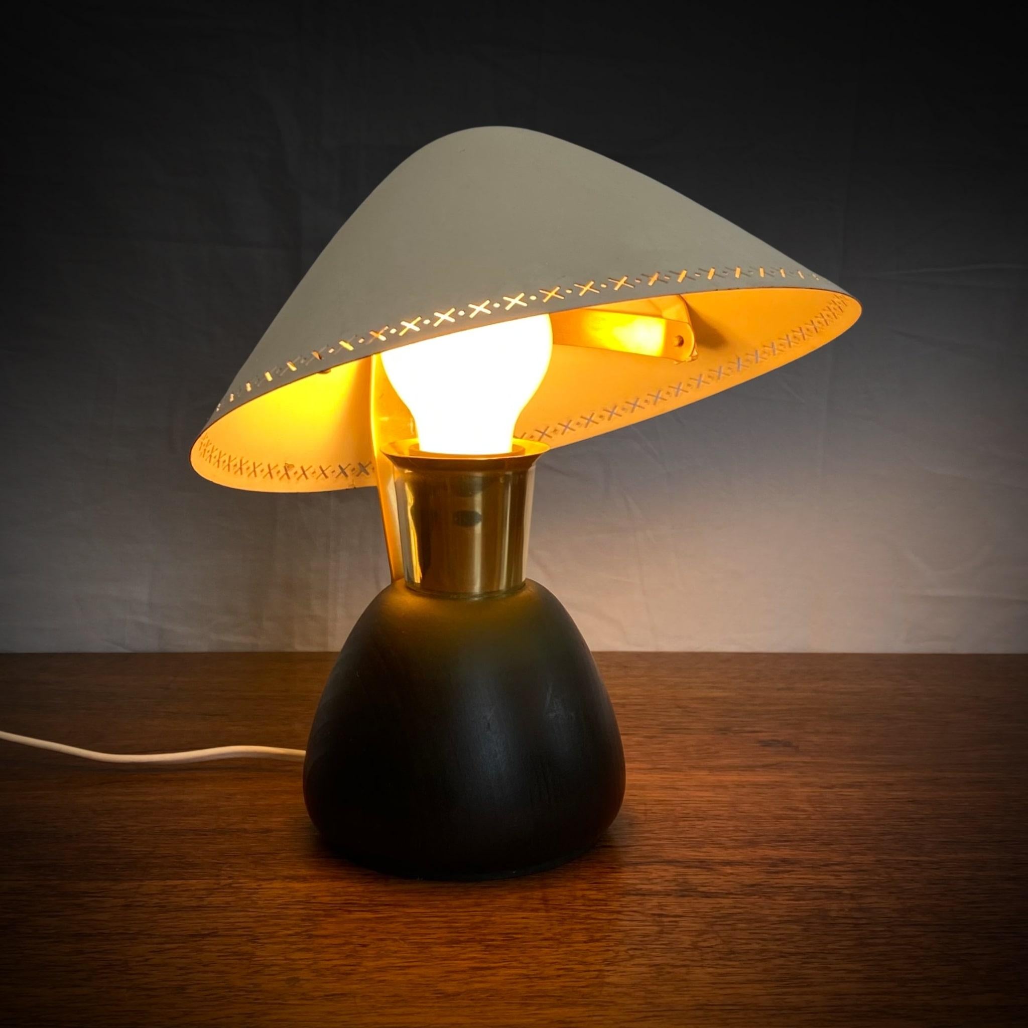 Rare ASEA table lamp, model E1272, dating back to the 1950s, featuring a rounded base crafted from solid wood. The disc shaped metal shade is adjustable and held in place by a brass arm.

ASEA, the Swedish electrical company, was established as
