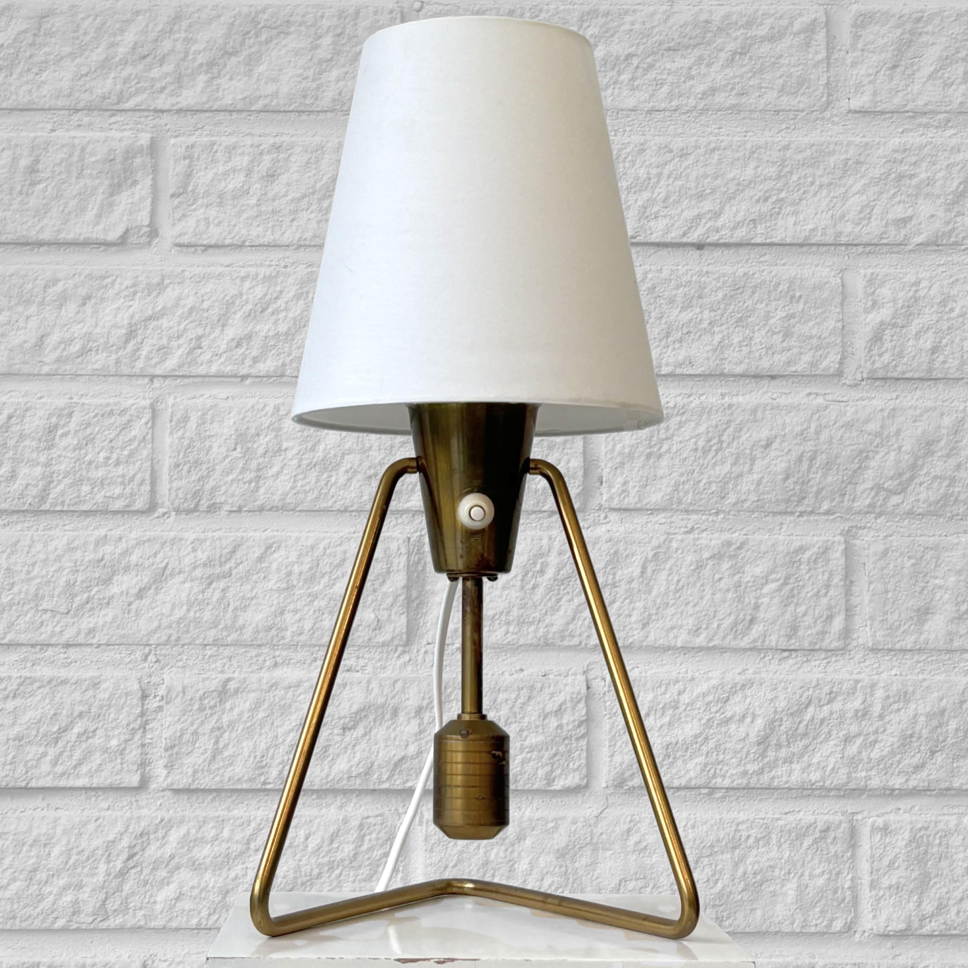 A modernist table lamp, model E1145, produced by the Swedish manufacturer ASEA Belysning in the 1950s. It features a strict geometric base supporting a lamp holder fitted with a counterweight, allowing the fixture to tilt and transform from a table