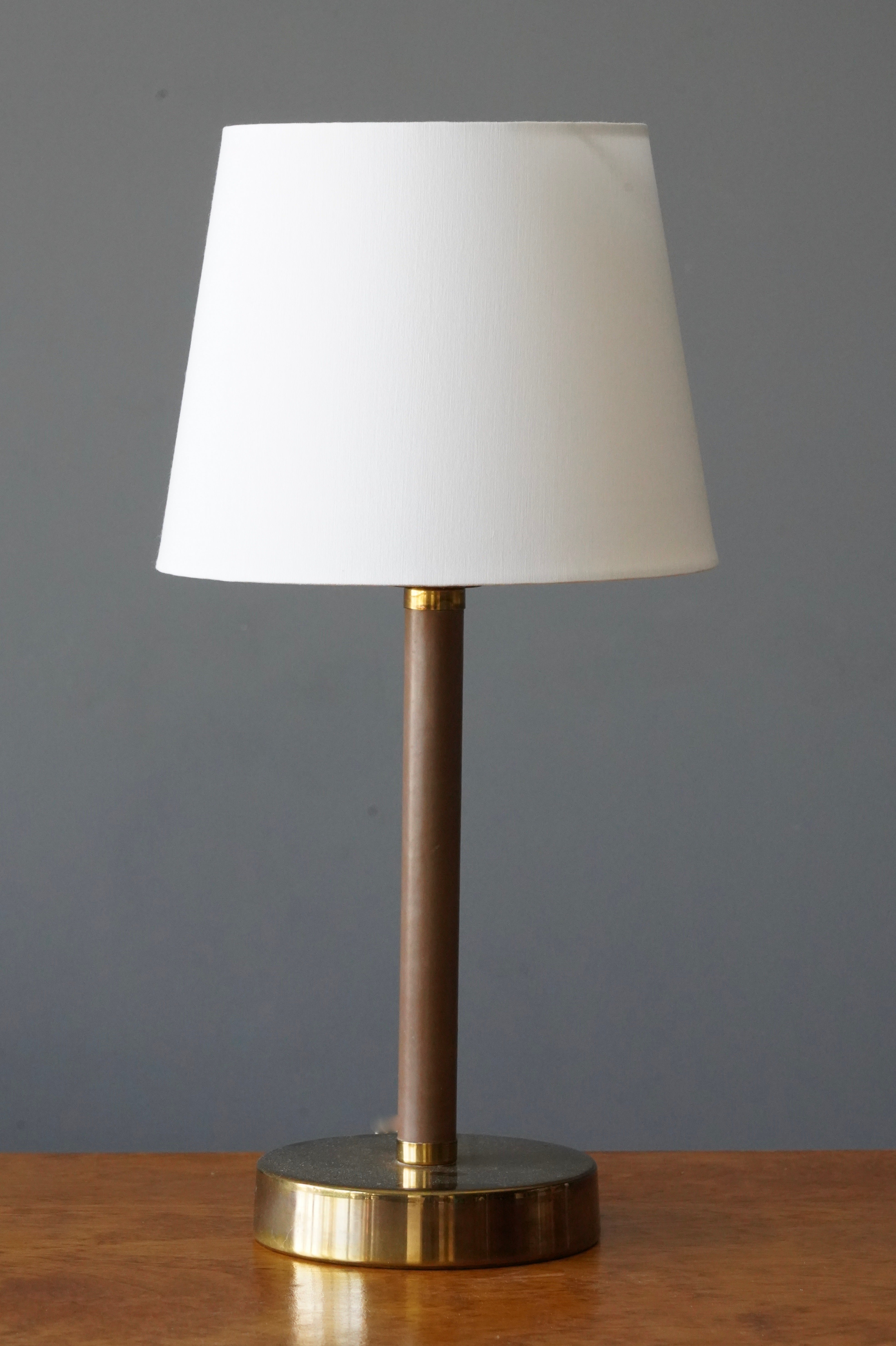 A table lamp, in brass and original brown leather. Designed and produced by ASEA, Sweden, 1950s.

Dimensions listed are without lampshade. Sold without lampshades.
Dimensions with shade: height is 20.5 inches, width is 10 inches.
Dimensions of