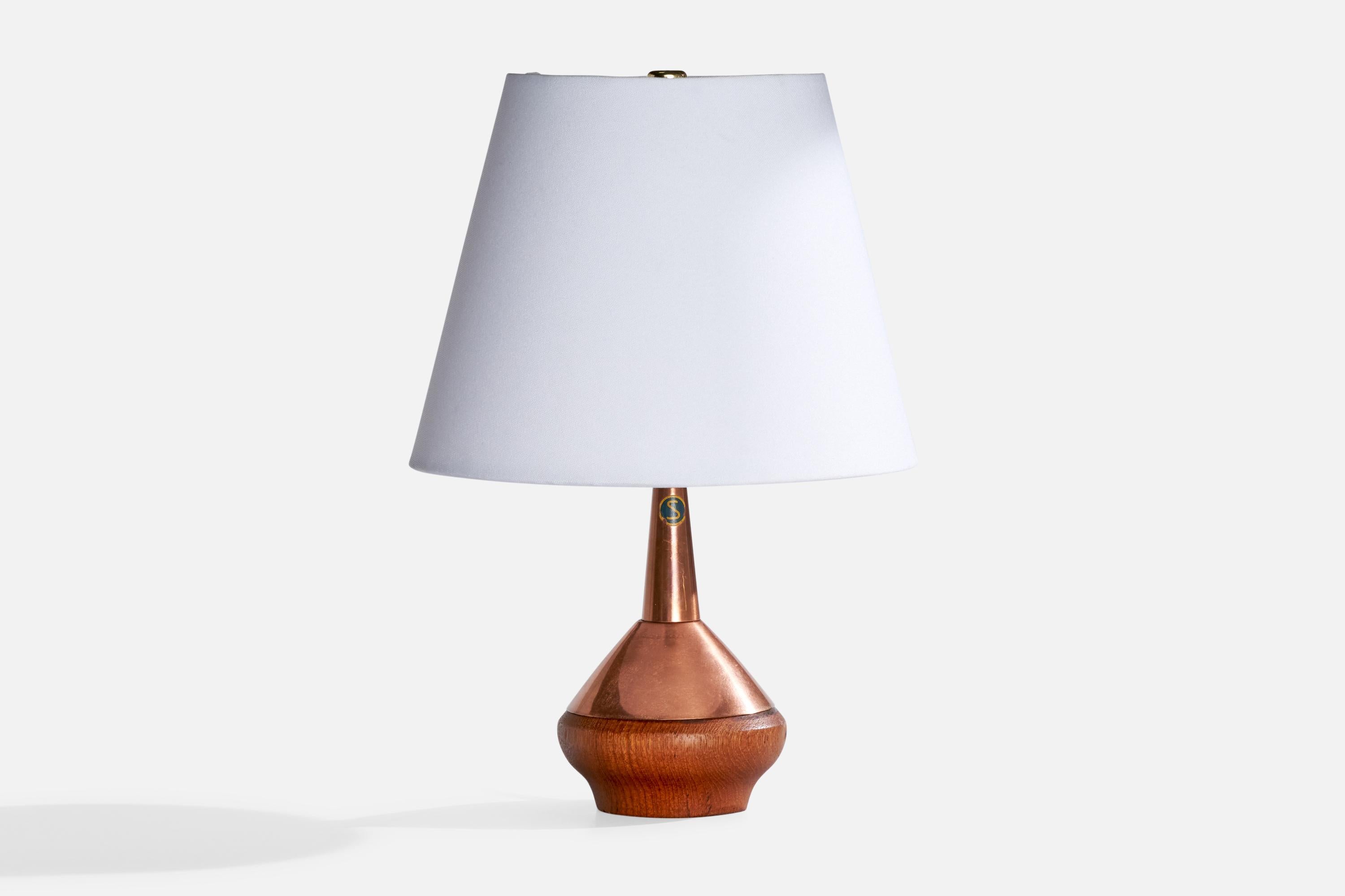 A copper and teak table lamp produced by ASEA, Sweden, c. 1950s.

Dimensions of Lamp (inches): 8.5” H x 3.75” Diameter

Dimensions of Shade: 5” Top Diameter x 8.25” Bottom Diameter x 6.5” H

Dimensions of Lamp with Shade (inches): 12“ H x 8.25“
