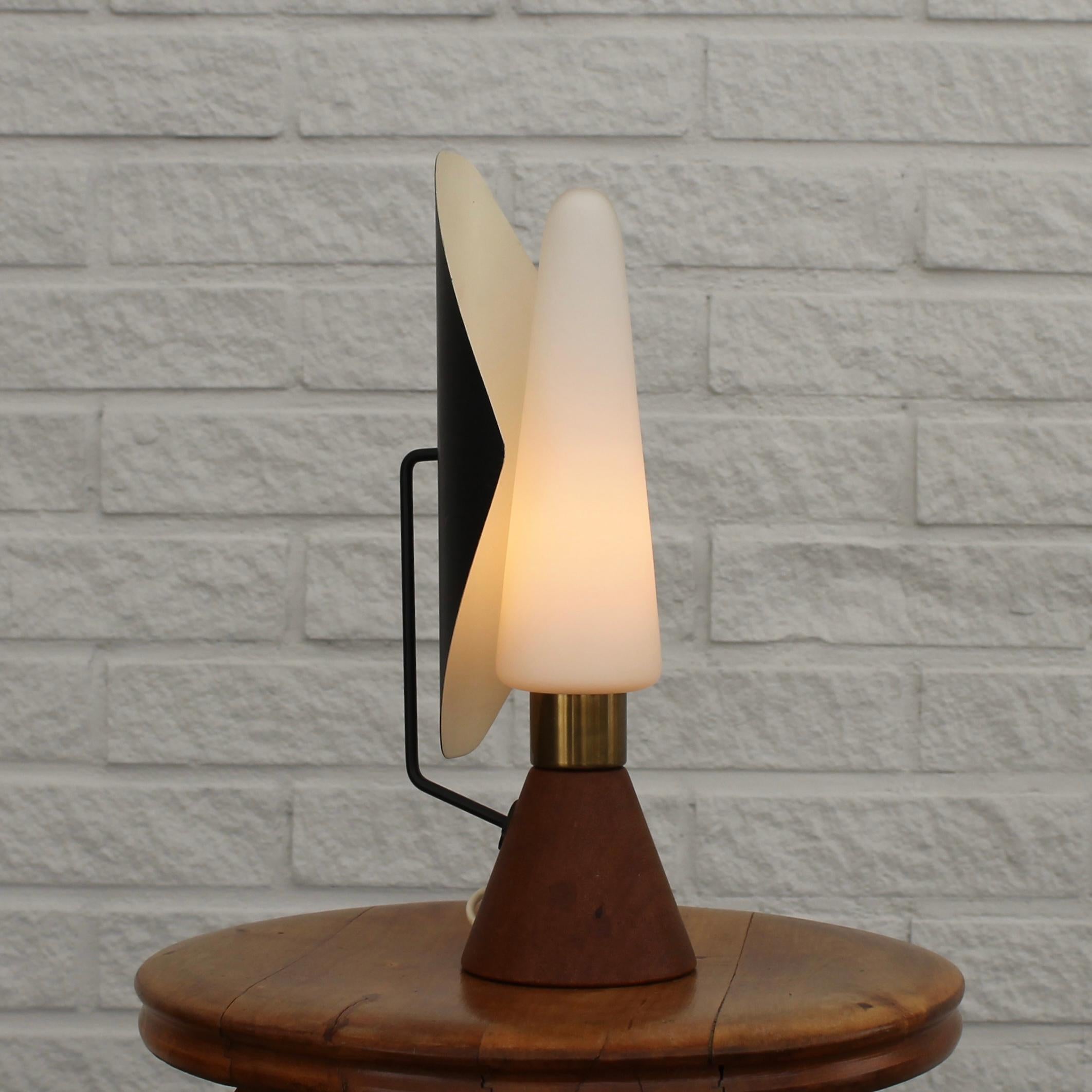 Rare ASEA table lamp, model E1296, dating back to the 1950s, featuring a cone-shaped base crafted from solid teak and an opaline glass shade secured by a brass cylinder. It incorporates a metal reflector, allowing for adjustable light direction.