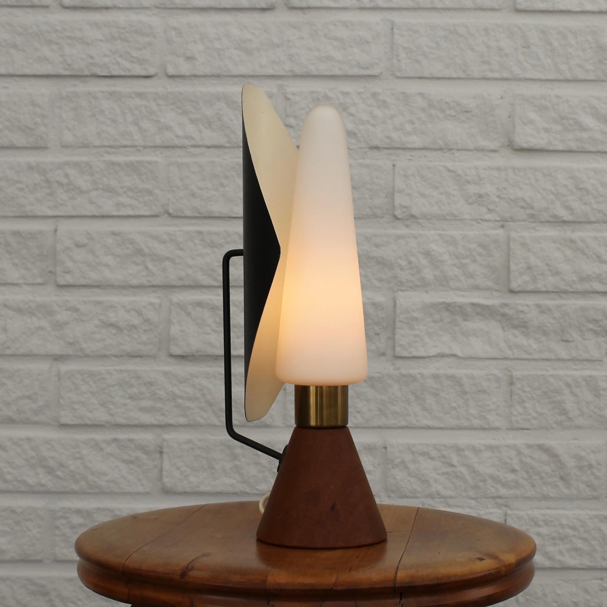 Rara lámpara de sobremesa ASEA, modelo E1296, de los años 50, con base cónica de teca maciza y pantalla de cristal opalino sujeta por un cilindro de latón. Incorpora un reflector metálico que permite ajustar la dirección de la luz. ASEA, la empresa