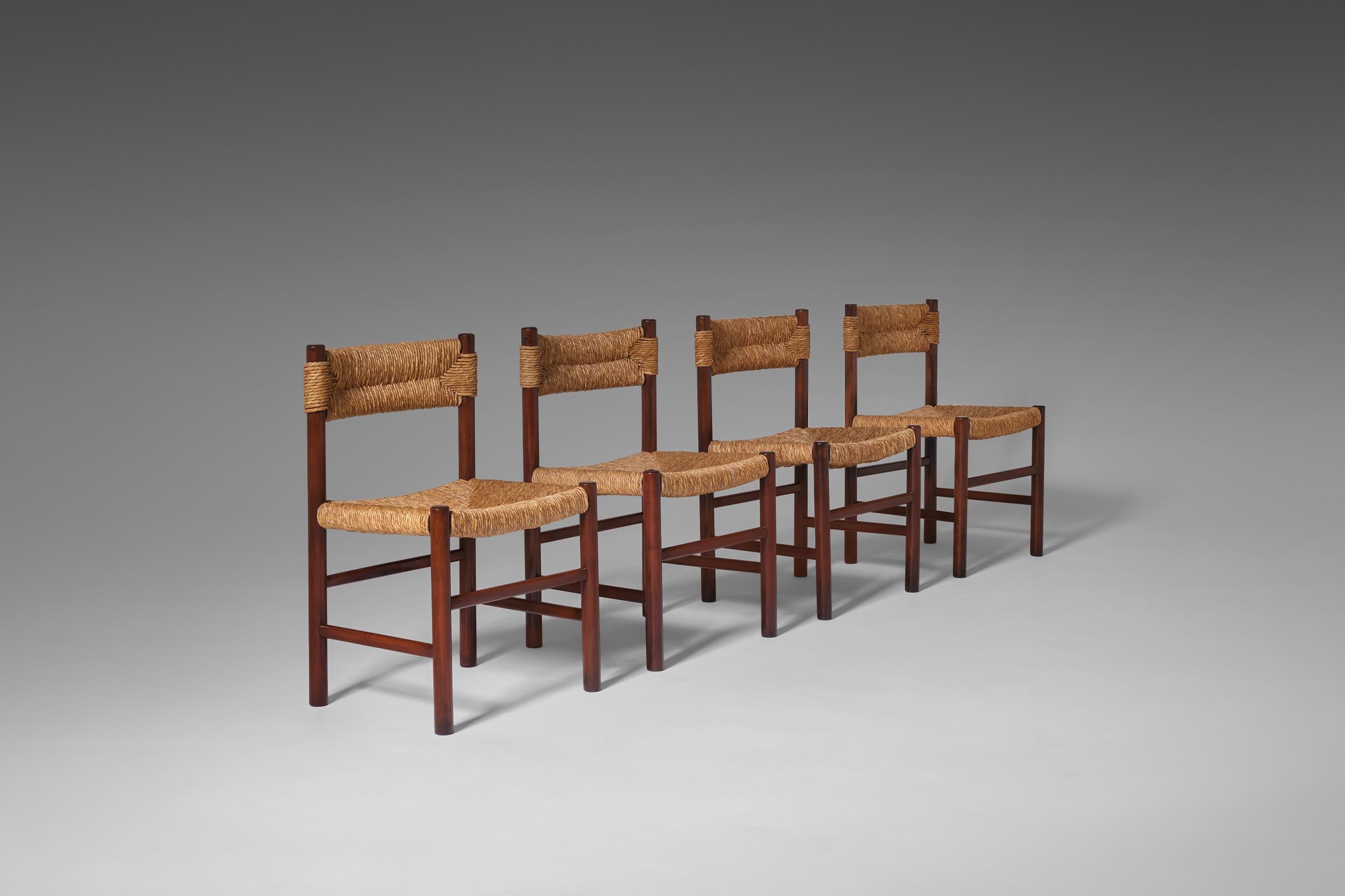 Set of four dining chairs, France, 1960's. Sculptural yet modest design often attributed to Robert Sentou for Charlotte Perriand. The chairs are made of solid stained Ash and rush seat and backrest in a beautiful woven pattern. The chairs provide a