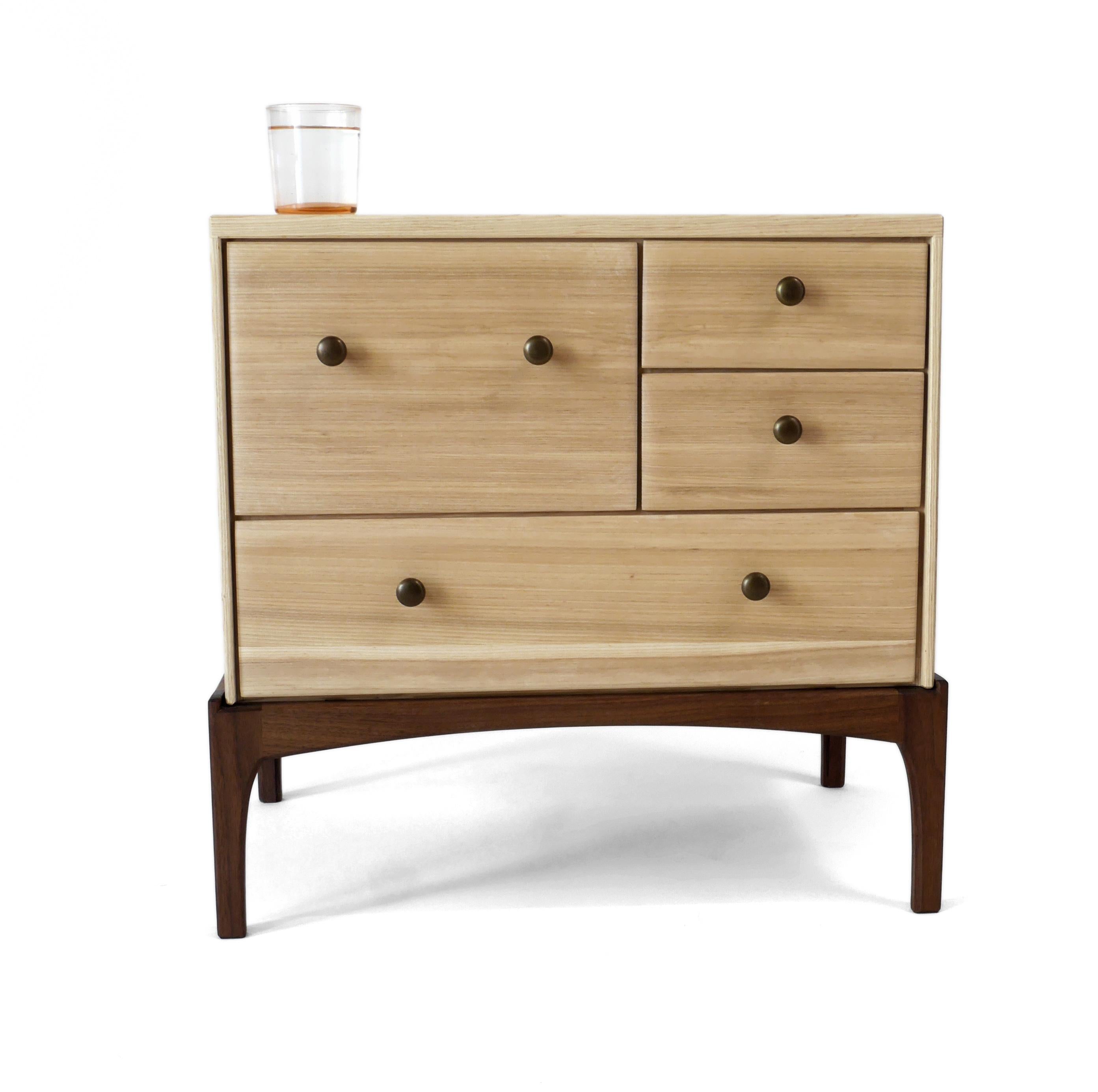 The stunning Arora Nightstand is built of solid ash hardwood with a black walnut stand. It has four drawers that all run on the finest soft closing ball bearing glides and is built with exposed joinery that has been carefully designed for beauty and
