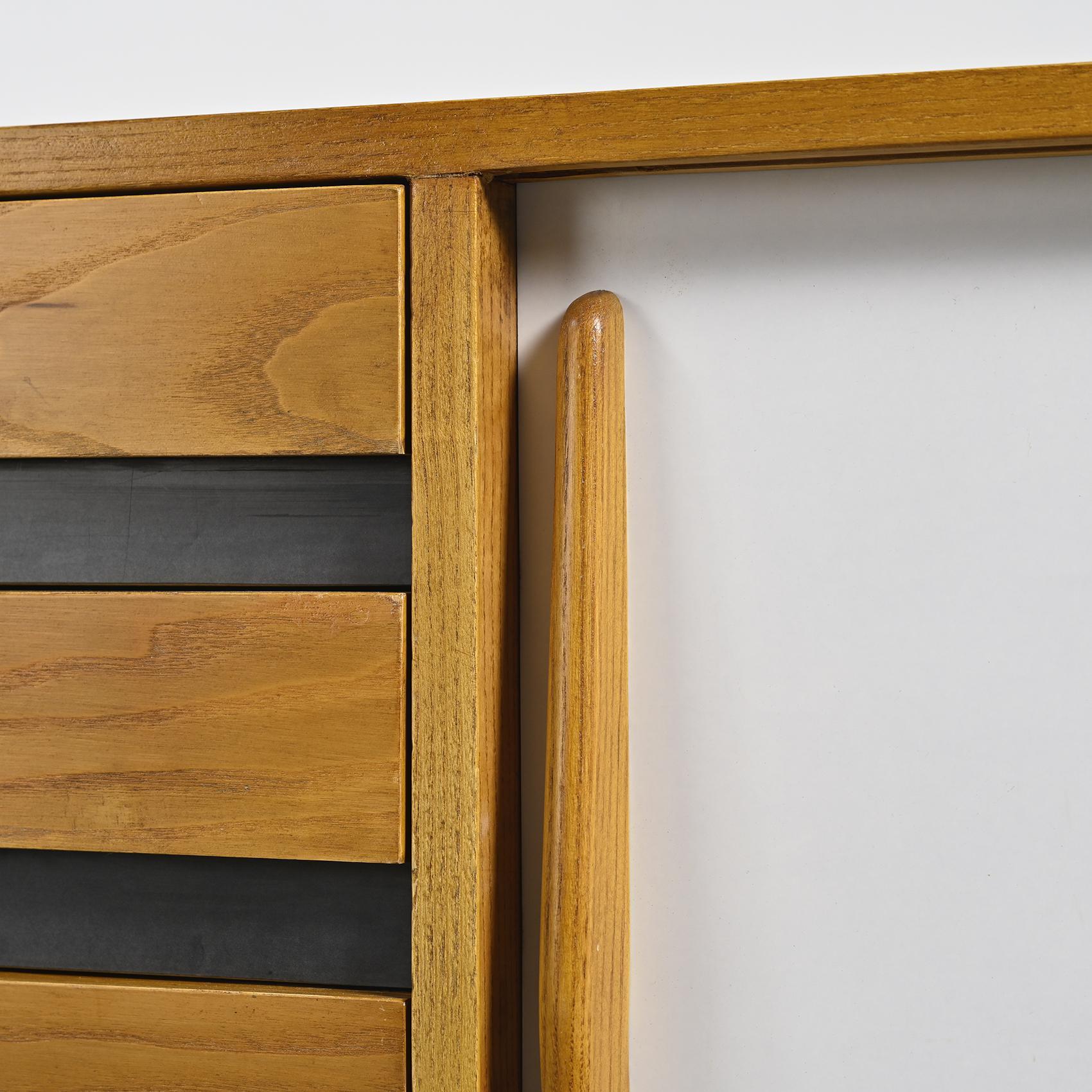 Cansado sideboard in ash veneer, with two black and white laminate sliding doors, as well as four wooden drawers, all resting on a base in black lacquered metal.

Cansado is a mining town built in the 1960s by the Mauritanian Iron Mines Company