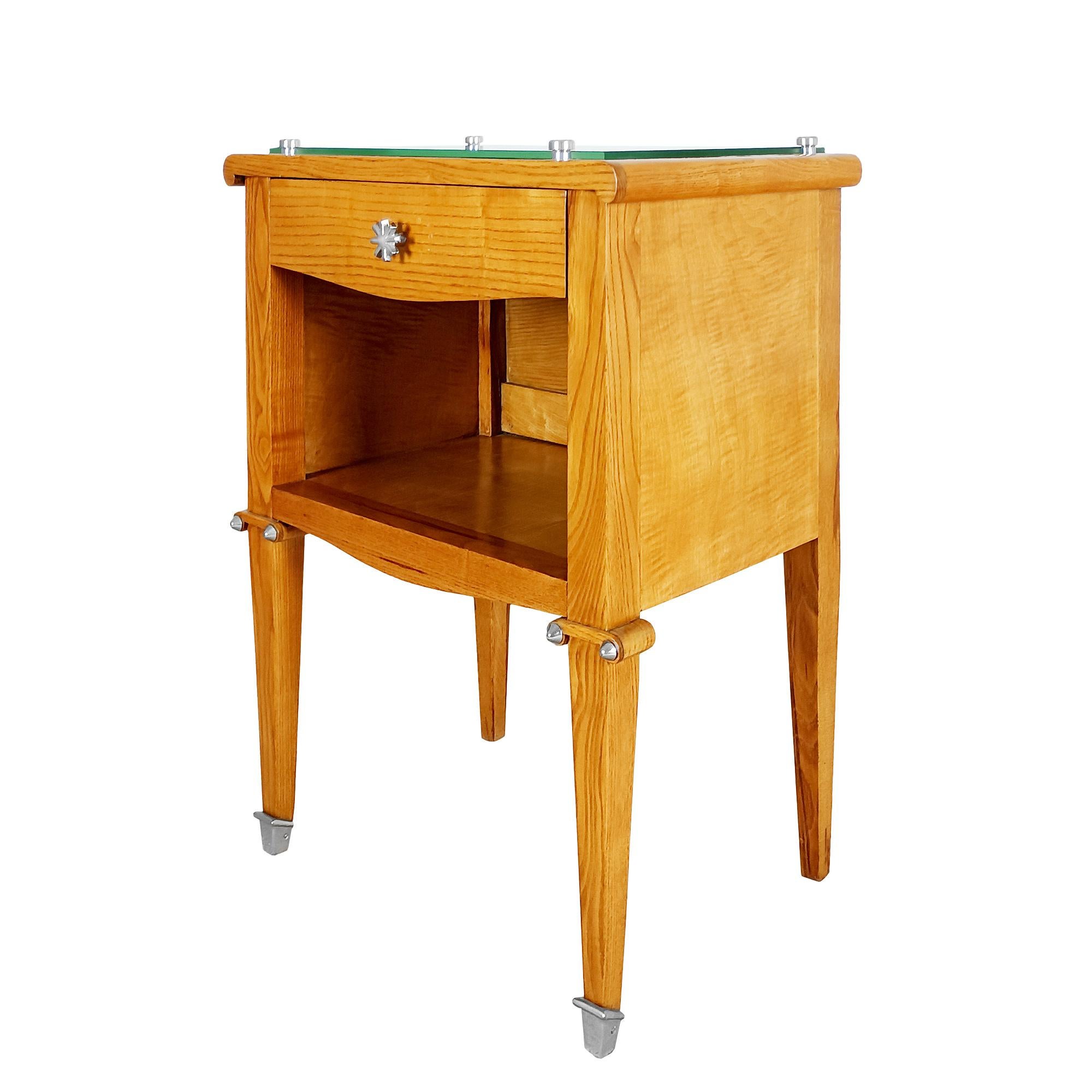 Solid ash with ash veneer bedside table, one drawer above an open niche, top partially covered with a mirror, nickel-plated metal finish, feet and handles. French polish.

France circa 1940