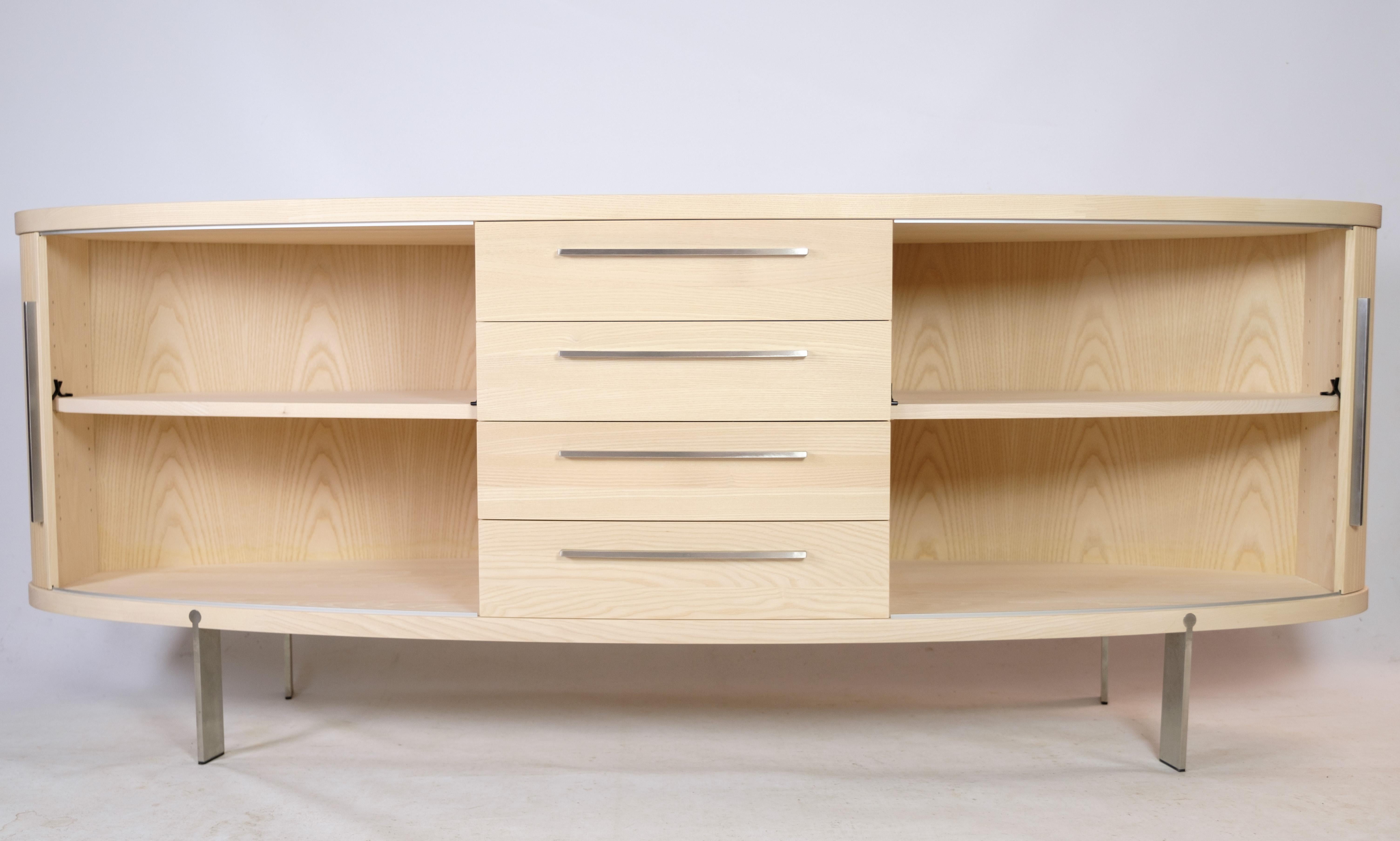 Sideboard in ash wood, model AK-1300, designed and manufactured by Naver Collection, a classic oval sideboard with shutter doors that has been given a modern twist. In like new condition with very few signs of use.
Length: 200 cm - Depth: 53 cm.