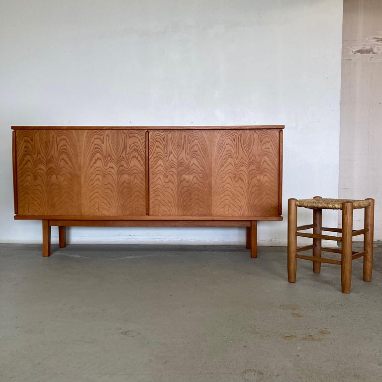 Mid-Century Modern sideboard with 2 large sliding doors.
Ash wood veneer and solid beech wood.
Made in France in the early 1950s.

Typical of the early 1950s, this sideboard is in the style Charlotte Perriand, Jean Prouvé and Le Corbusier.
it