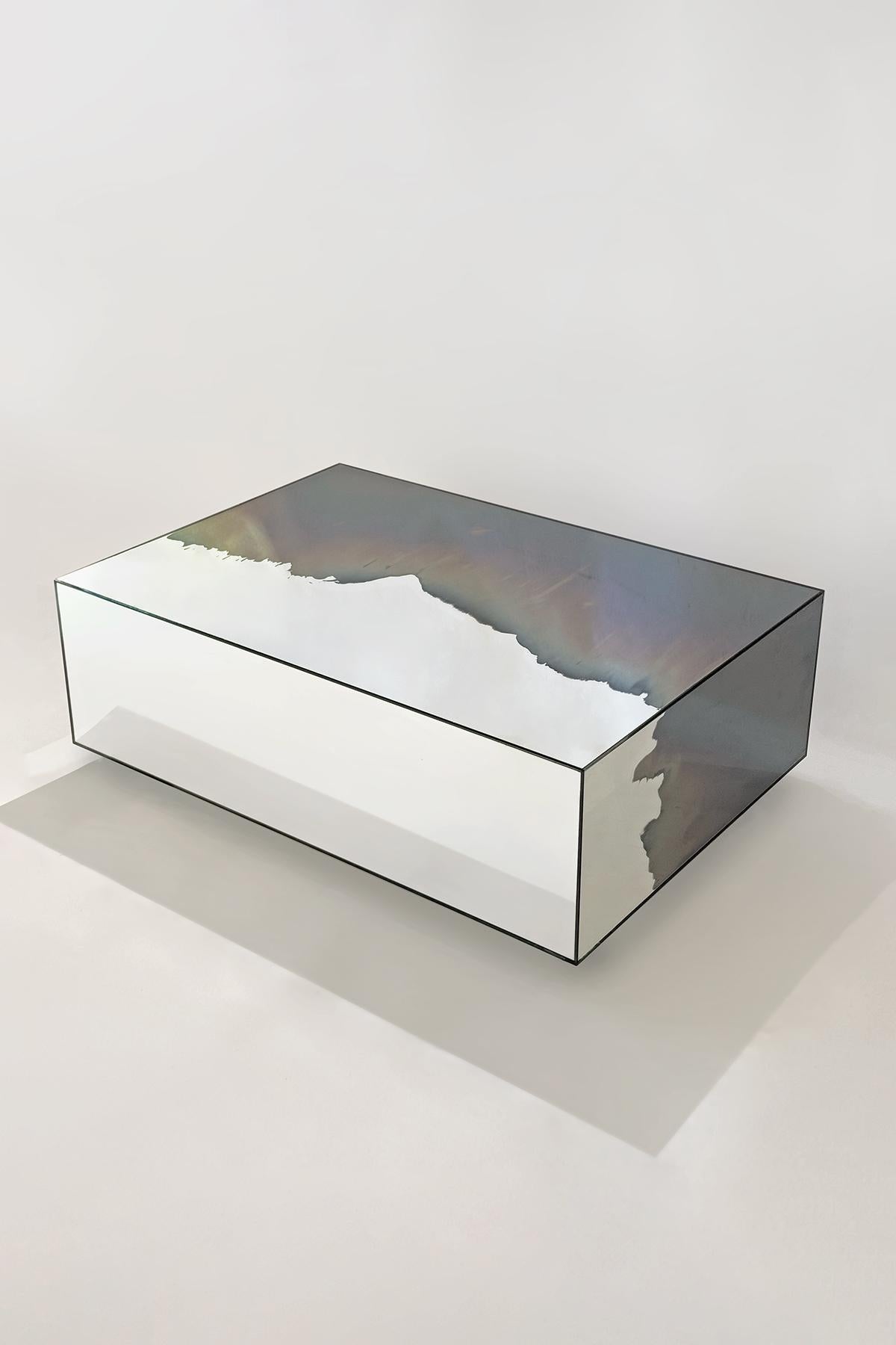Table sculpturale en frêne fumée et miroir argenté Homa
Dimensions : L 100 x D 70 x H 30 cm
MATERIAL : Fumée et argent Miroir.

HOMA est un atelier de design contemporain basé à Istanbul. Les procédés caractéristiques de l'atelier sont le verre