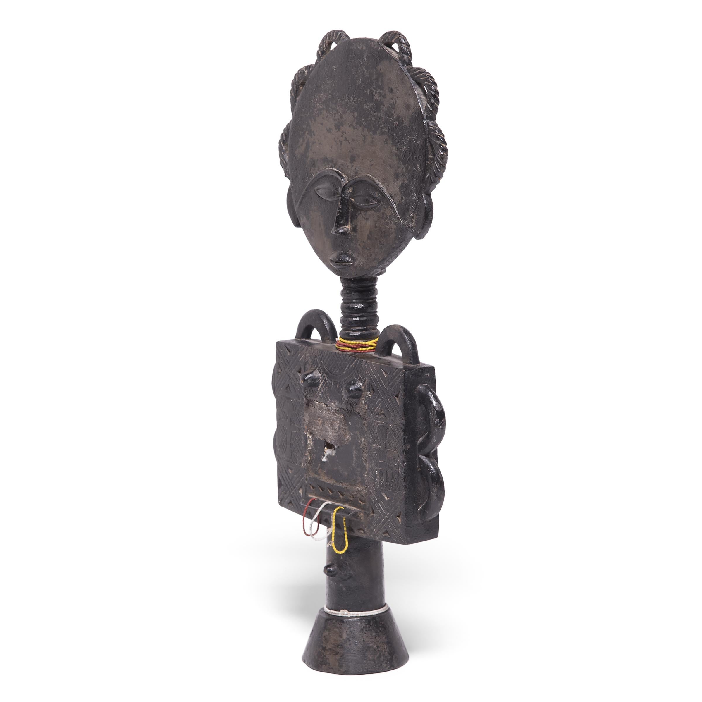 Disc-headed Acua'ba figures such as this one served an important role in Ashanti society. They began as a promise for a beautiful child, and in the event that the child disappeared, the figure would be offered to the responsible malevolent spirit in
