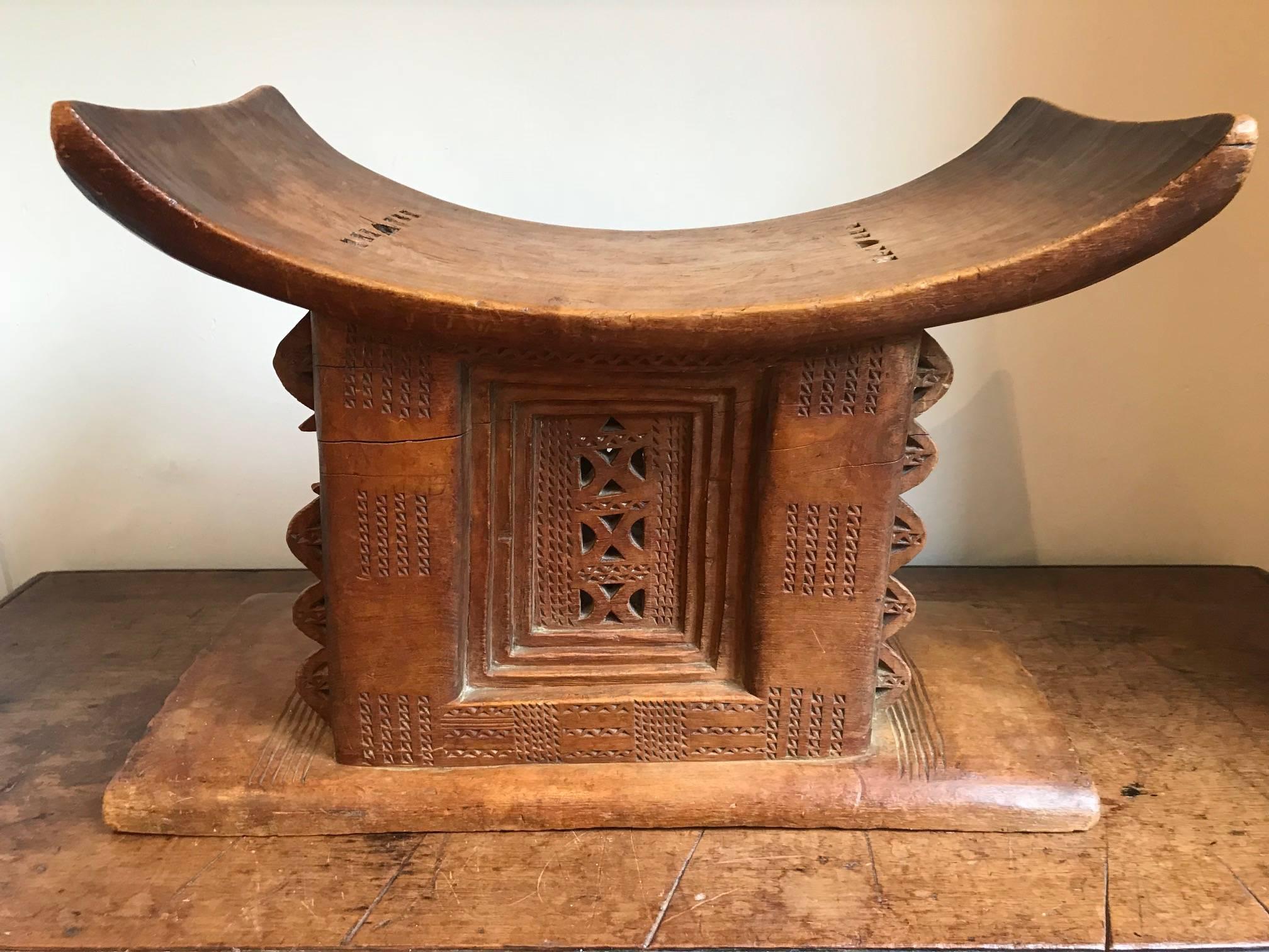 A good example of an early to mid-20th century Ashanti or Asante Tribal stool used by the Akua Ba tribe, with intricate carving. Some damage which is apparent in the photos. Has been well used with excellent patination. Strong can be used as a stool