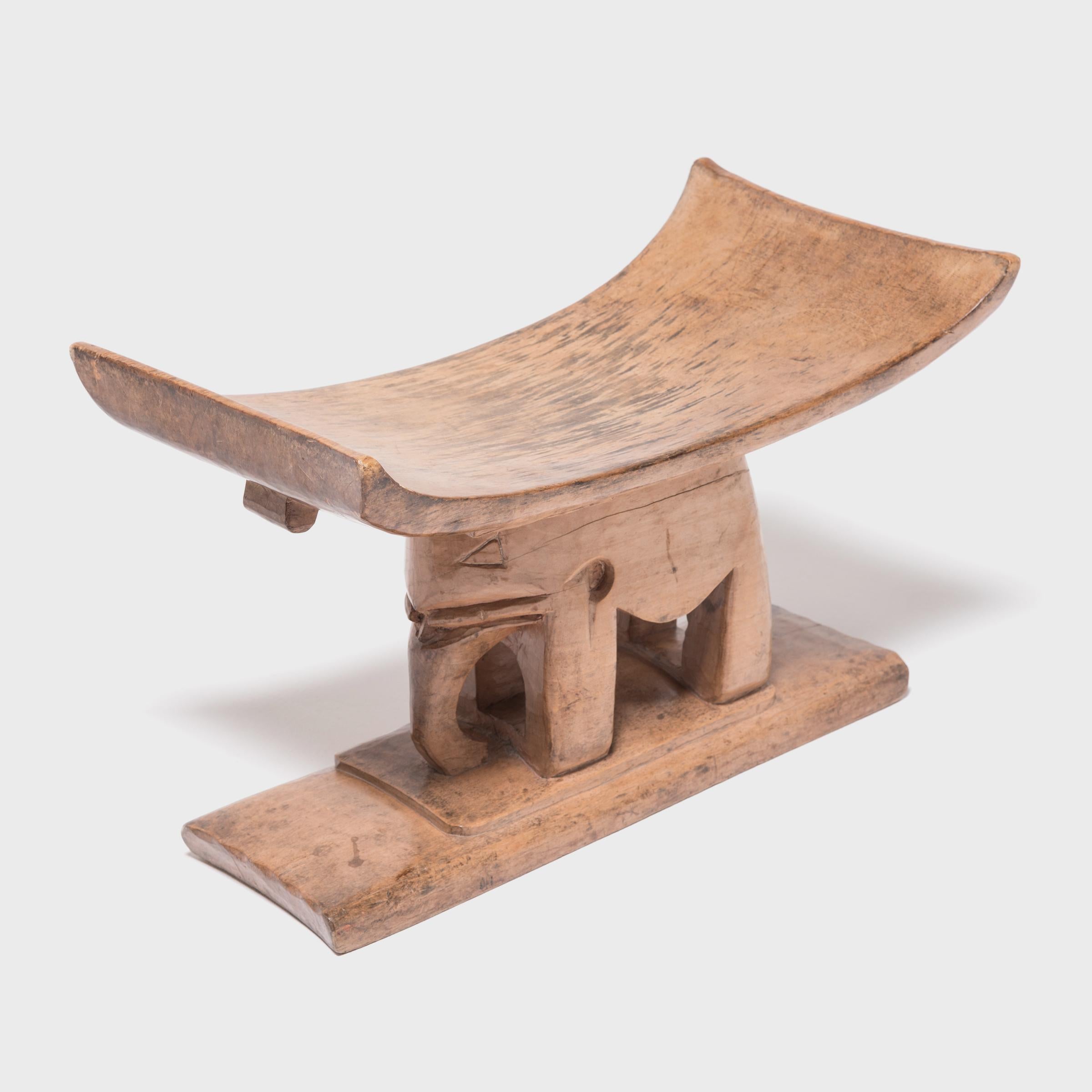 In traditional Ashanti culture of central Ghana, stools indicate power, status, and lines of succession. The flat base, curved seat, and ridged supports of this particular hand carved stool reference the Ashanti King stool. This distinctive form,