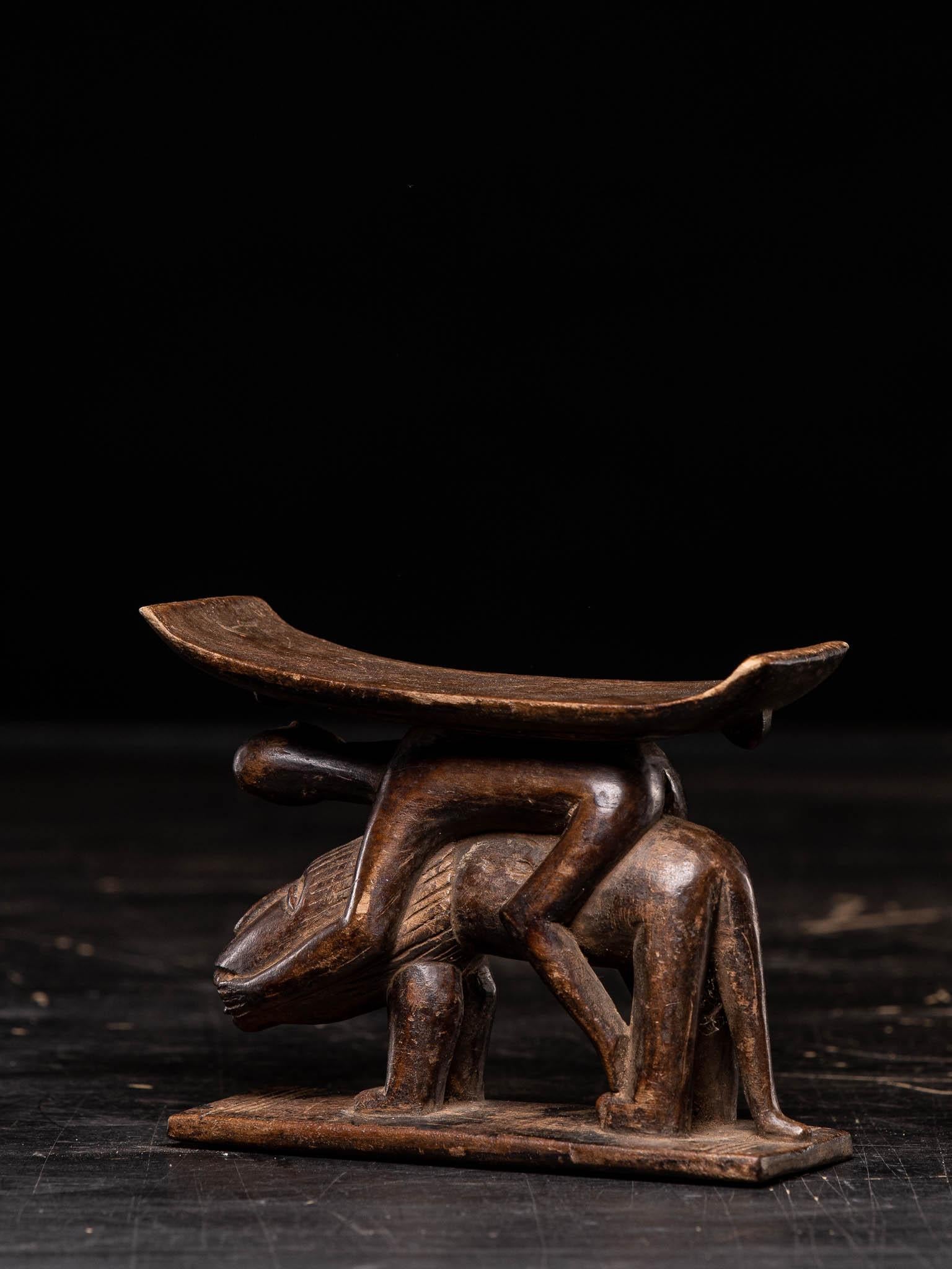 Ashanti Headrest Stool Carved Wood Tribal Art Ghana Africa

Carved from a single piece of wood, the African Ashanti head rest, Ghana, has a curved top raised on a pedestals depicting a man riding a lion.